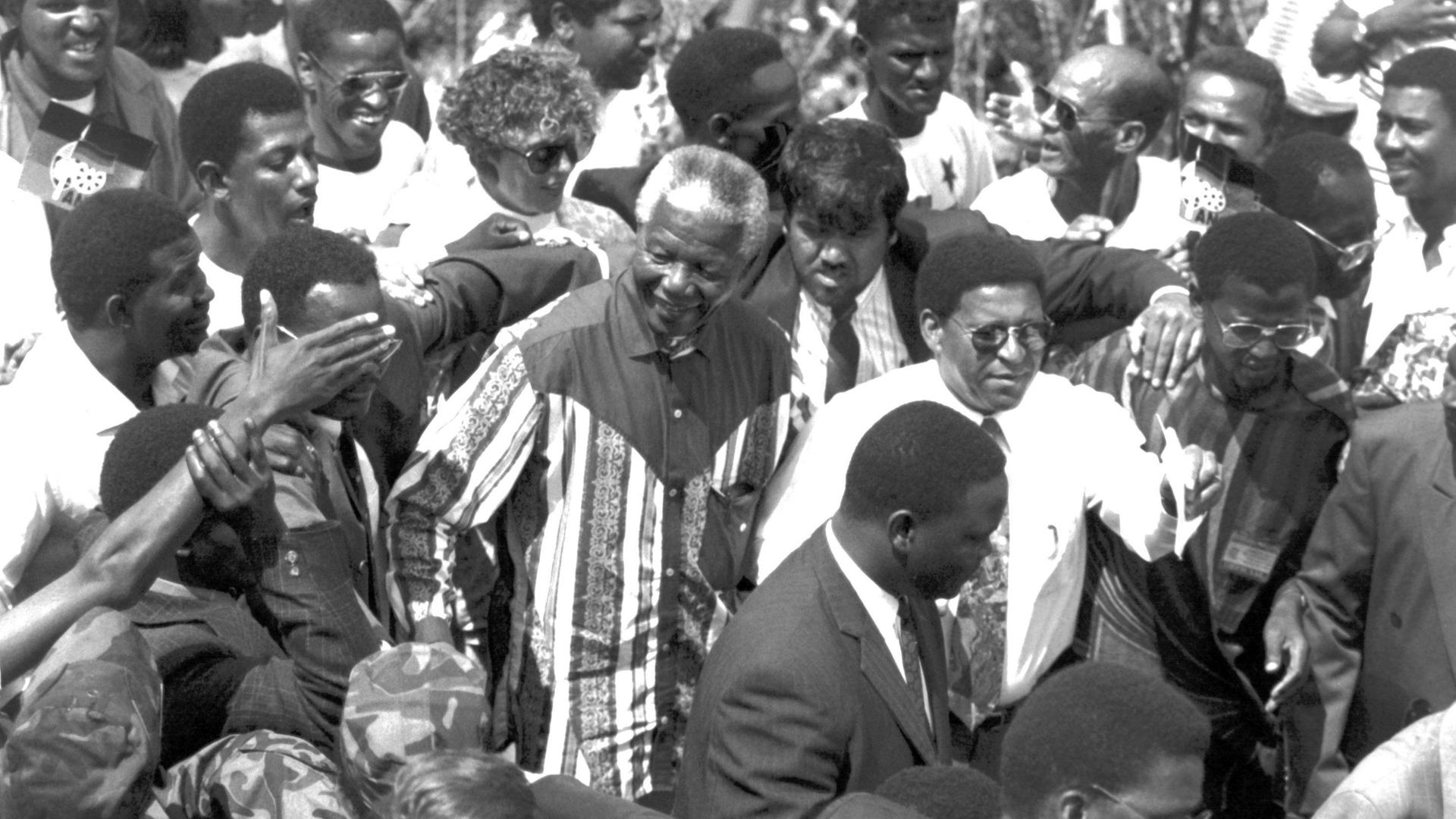 Viele Menschen jubeln Nelson Mandela zu. Es ist eine schwarz-weiß Aufnahme