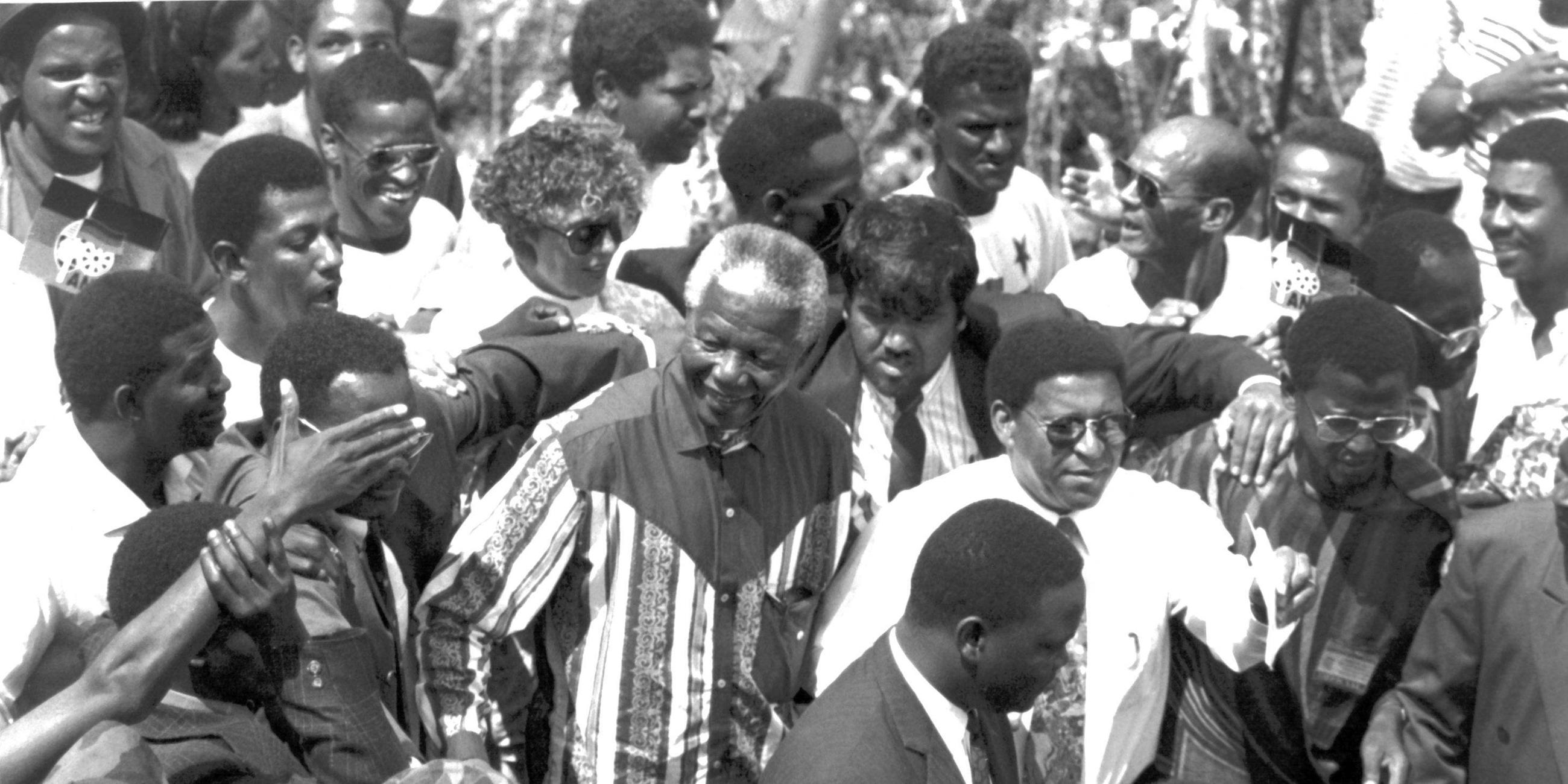 Viele Menschen jubeln Nelson Mandela zu. Es ist eine schwarz-weiß Aufnahme
