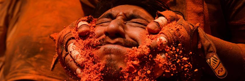 Mann mit orangenen Puder im Gesicht beim Sindoor Jatra Fest in Nepal