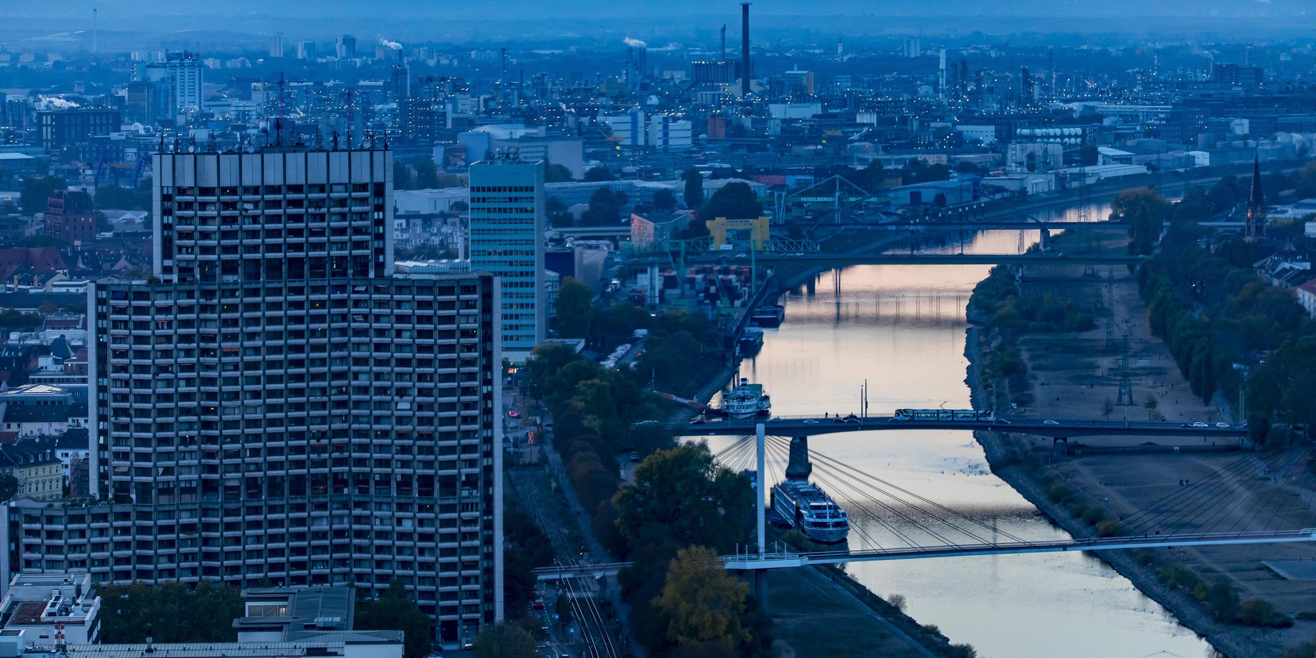 Ansicht der Stadt Mannheim von oben mit dem Rhein in der Abenddämmerung.