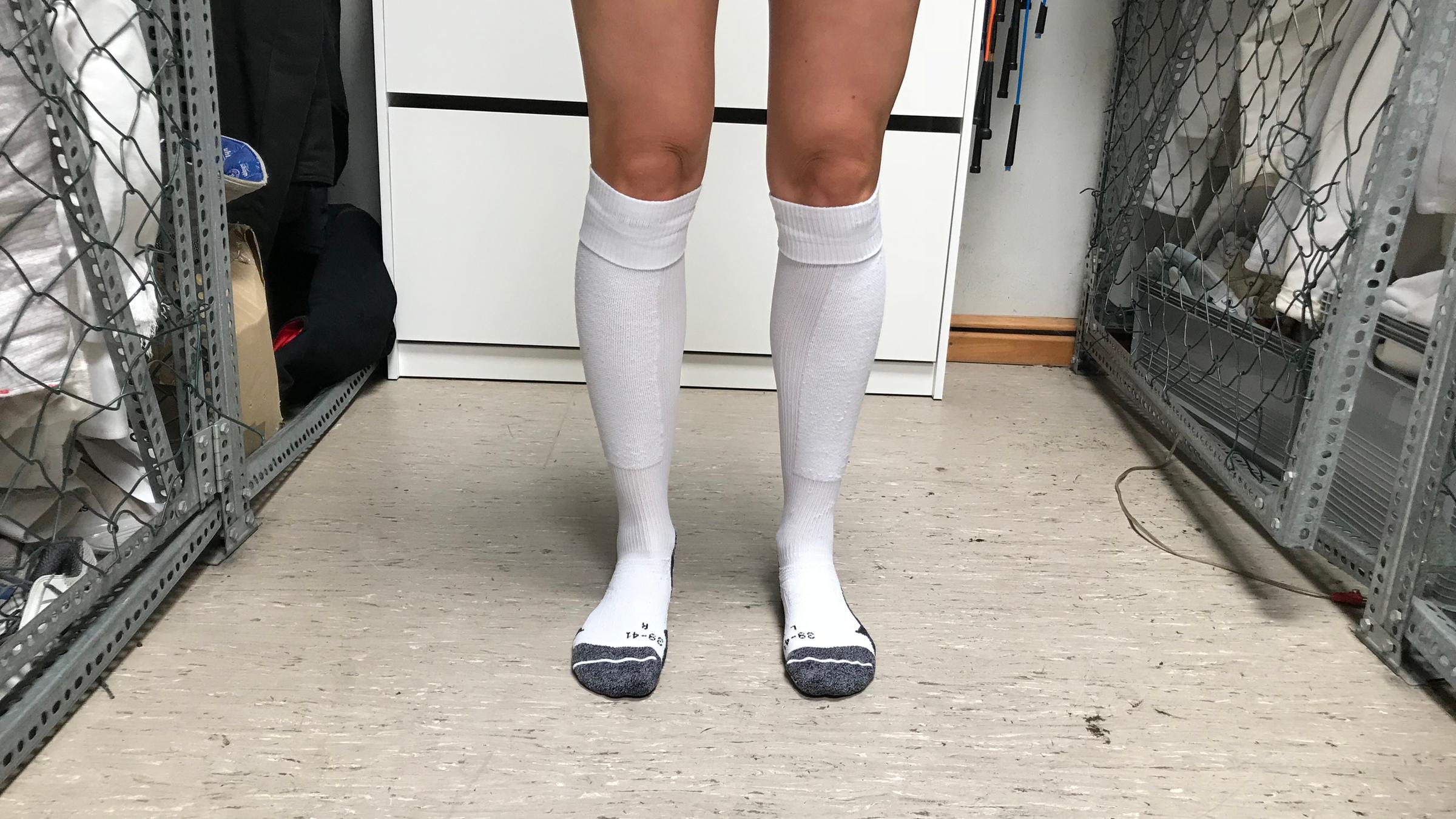 Maral zieht sich Socken zum Fechten an.
