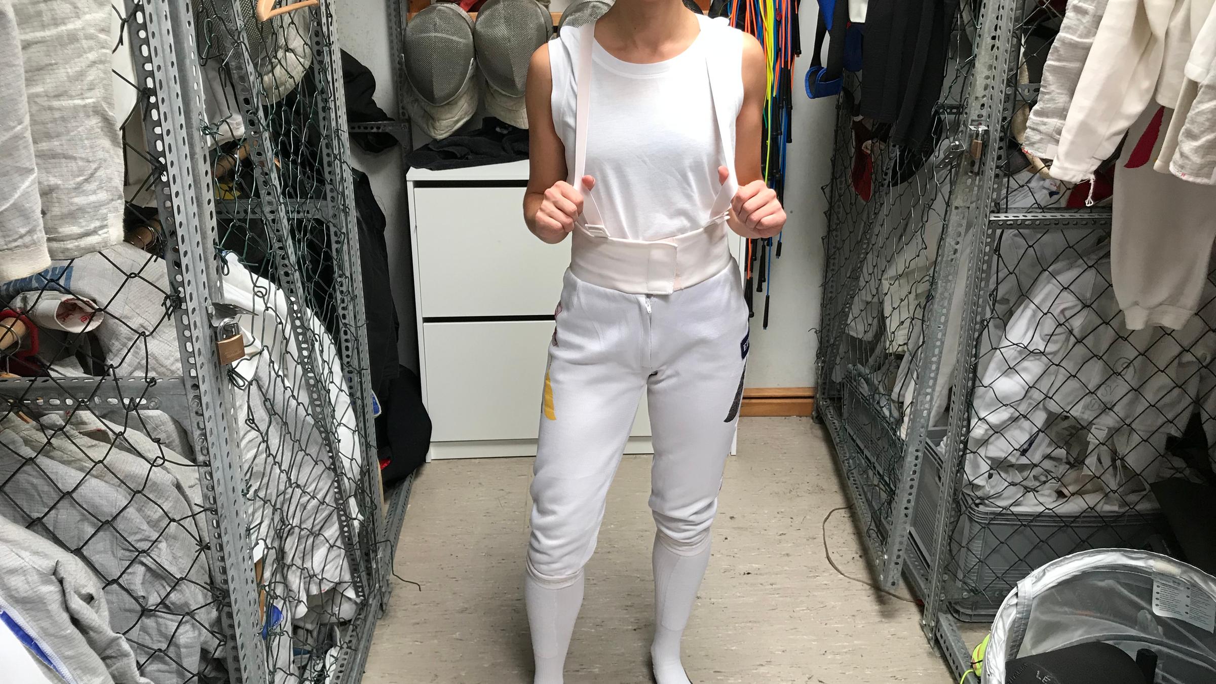 Maral zieht sich eine Hose zum Fechten an.