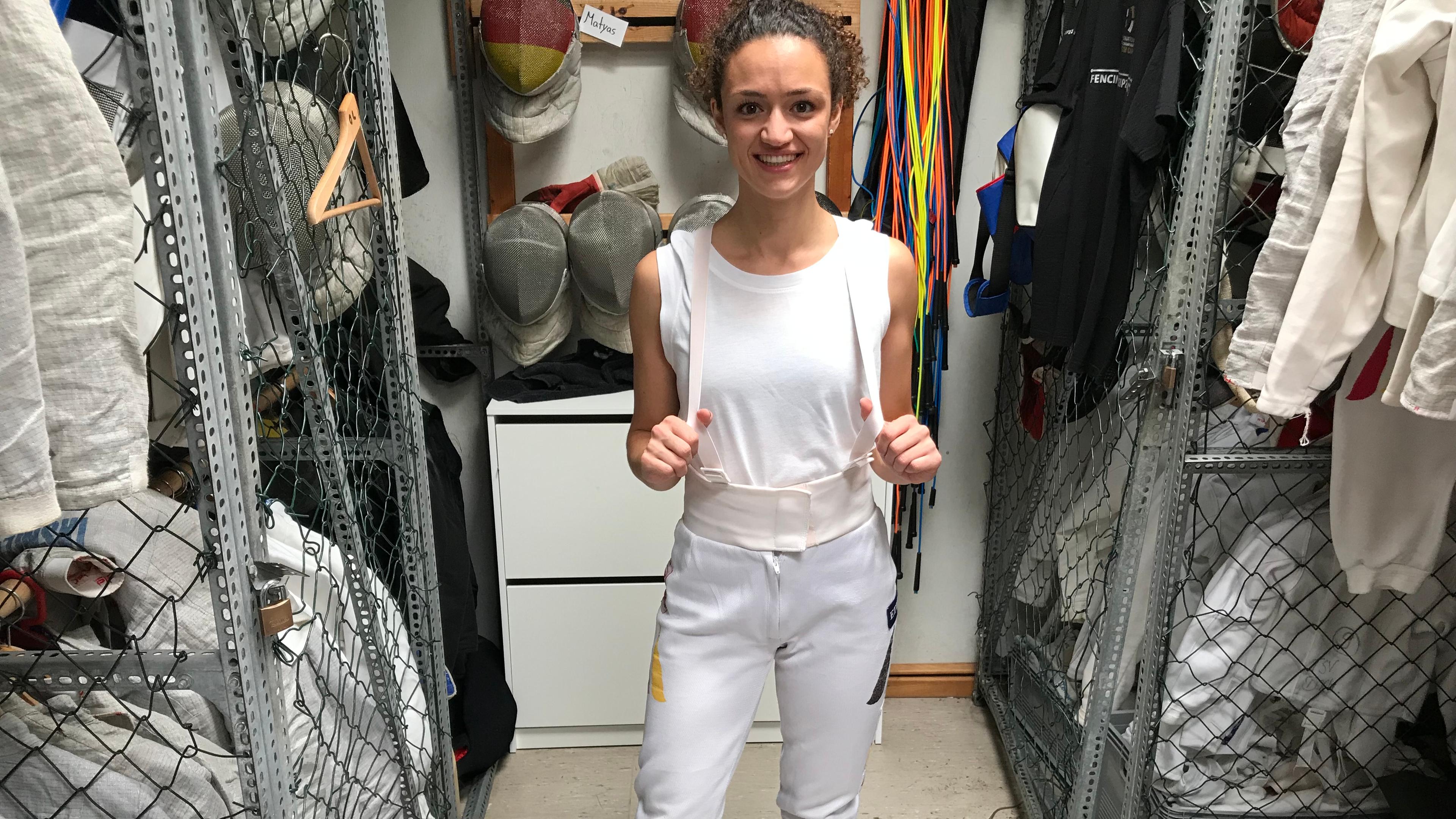 Maral zieht sich eine Hose zum Fechten an.