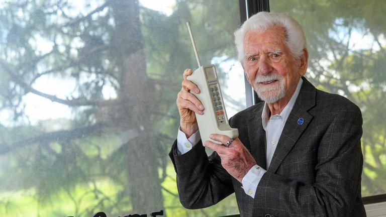 Ingenieur Martin Cooper posiert mit einer zeitgenössischen Kopie des Originalhandys, mit dem er am 3. April 1973 den ersten Handyanruf getätigt hat.