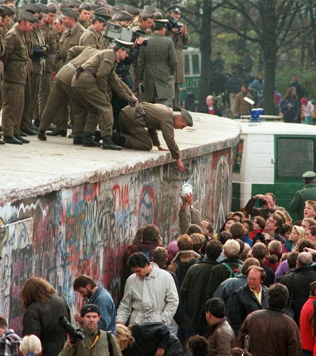Demonstranten und Grenzpolizisten an der Mauer