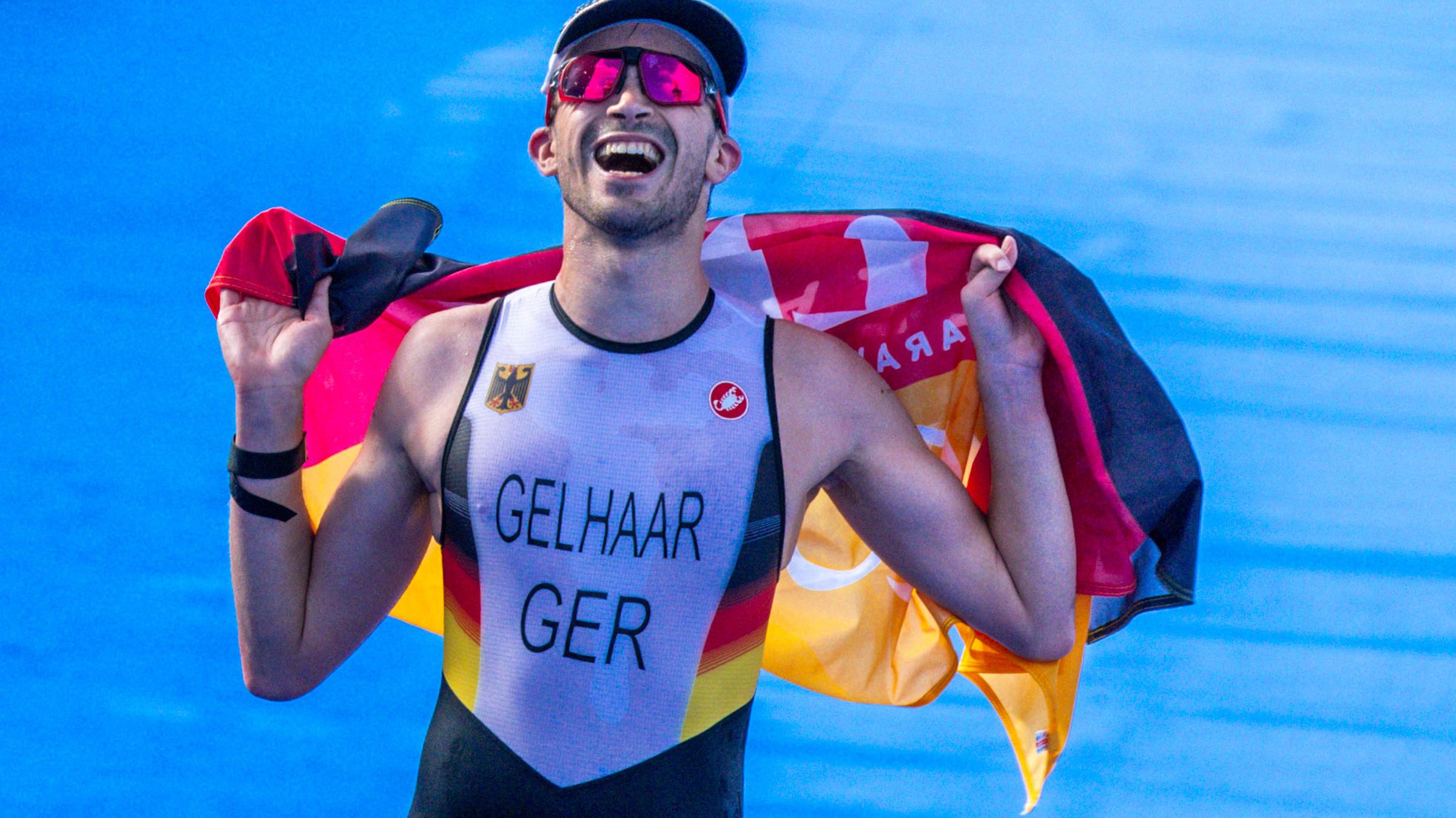 Max Gelhaar läuft grinsend mit Deutschland-Flagge in den Händen