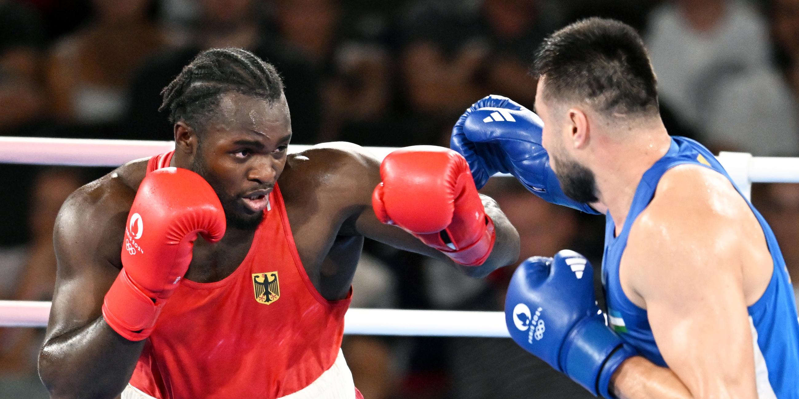 Rot gekleideter Boxer boxt gegen blau gekleideten Boxer