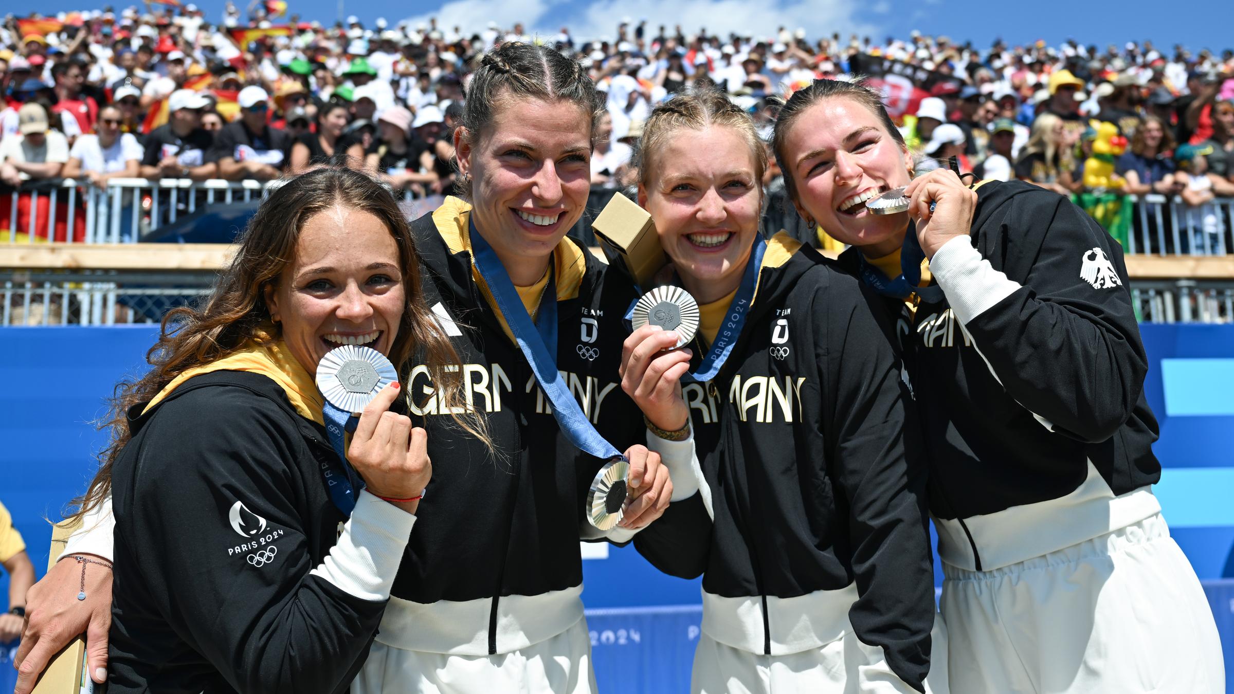 Vier Frauen schauen in die Kamera mit Silbermedaillen