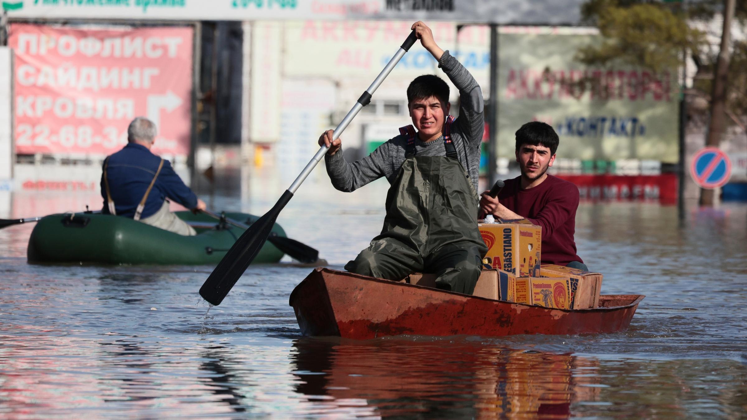 Zwei Menschen in einem Boot in einer überschwemmten Stadt