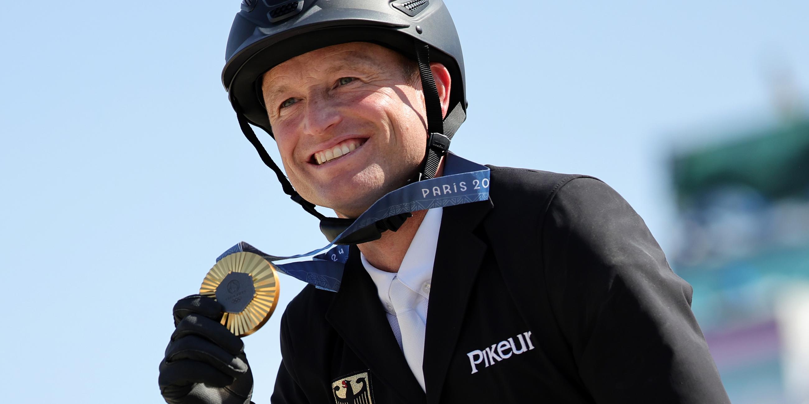 Michael Jung hält seine Goldmedaille in den Händen