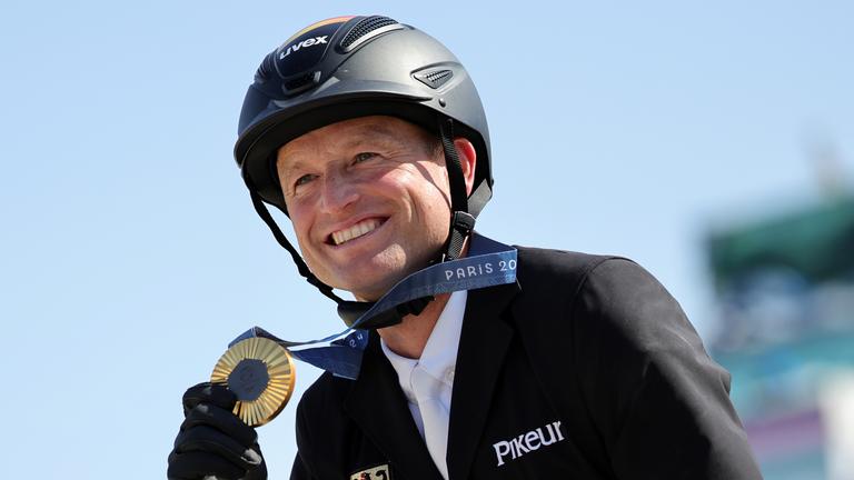 Michael Jung hält seine Goldmedaille in den Händen