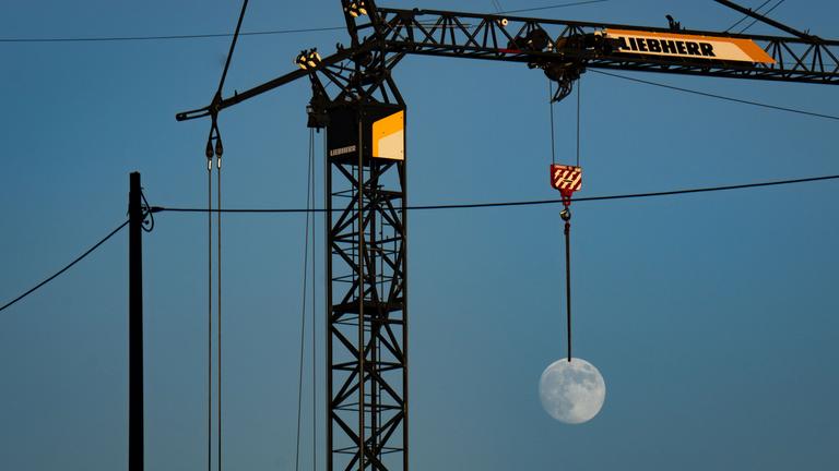 Mond scheint an Baukran zu hängen