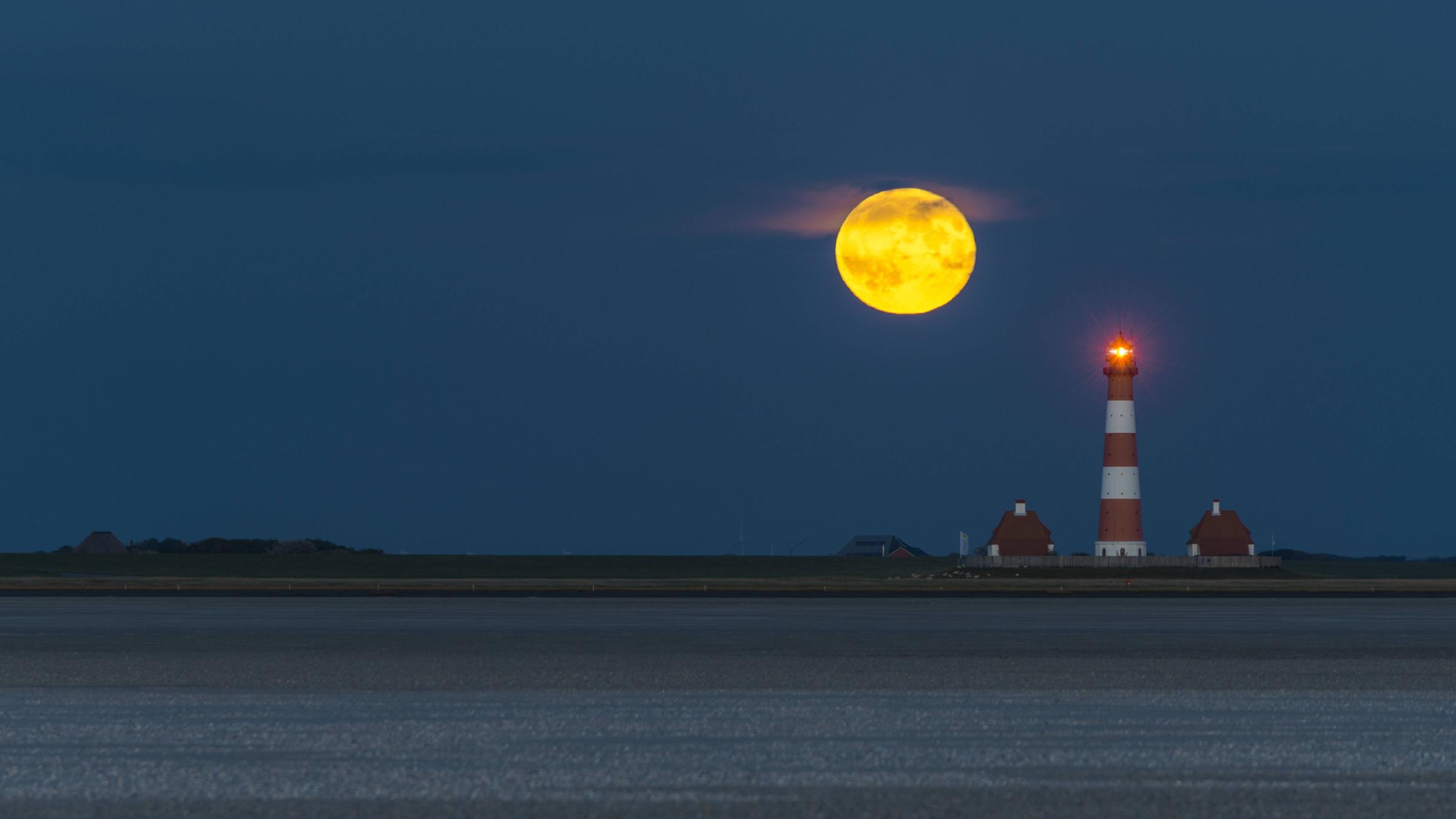 Der Mond sorgt vor einer Küste für Ebbe.