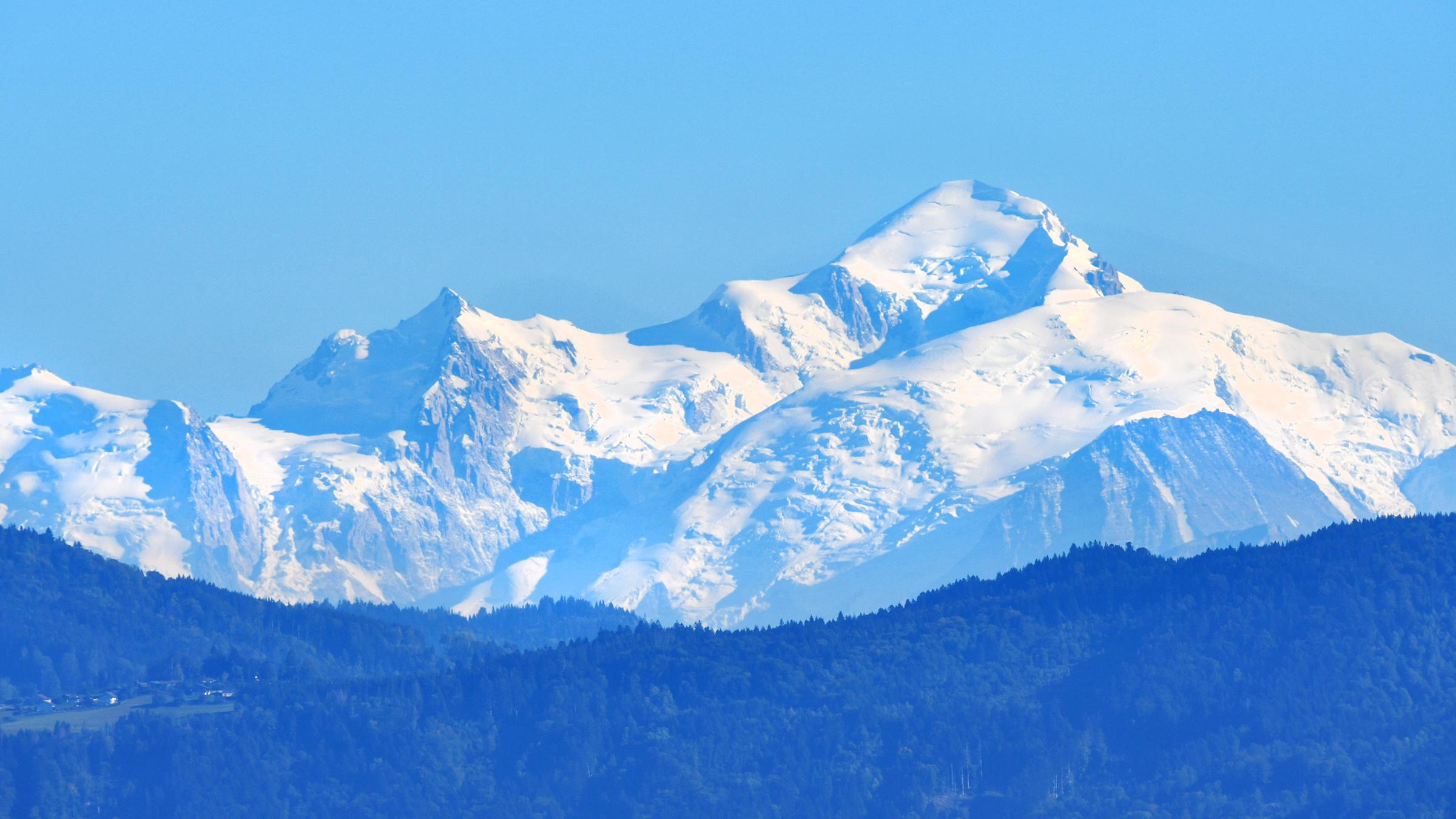 Man sieht den schneebedeckten Mont Blanc vor blauem Himmel.