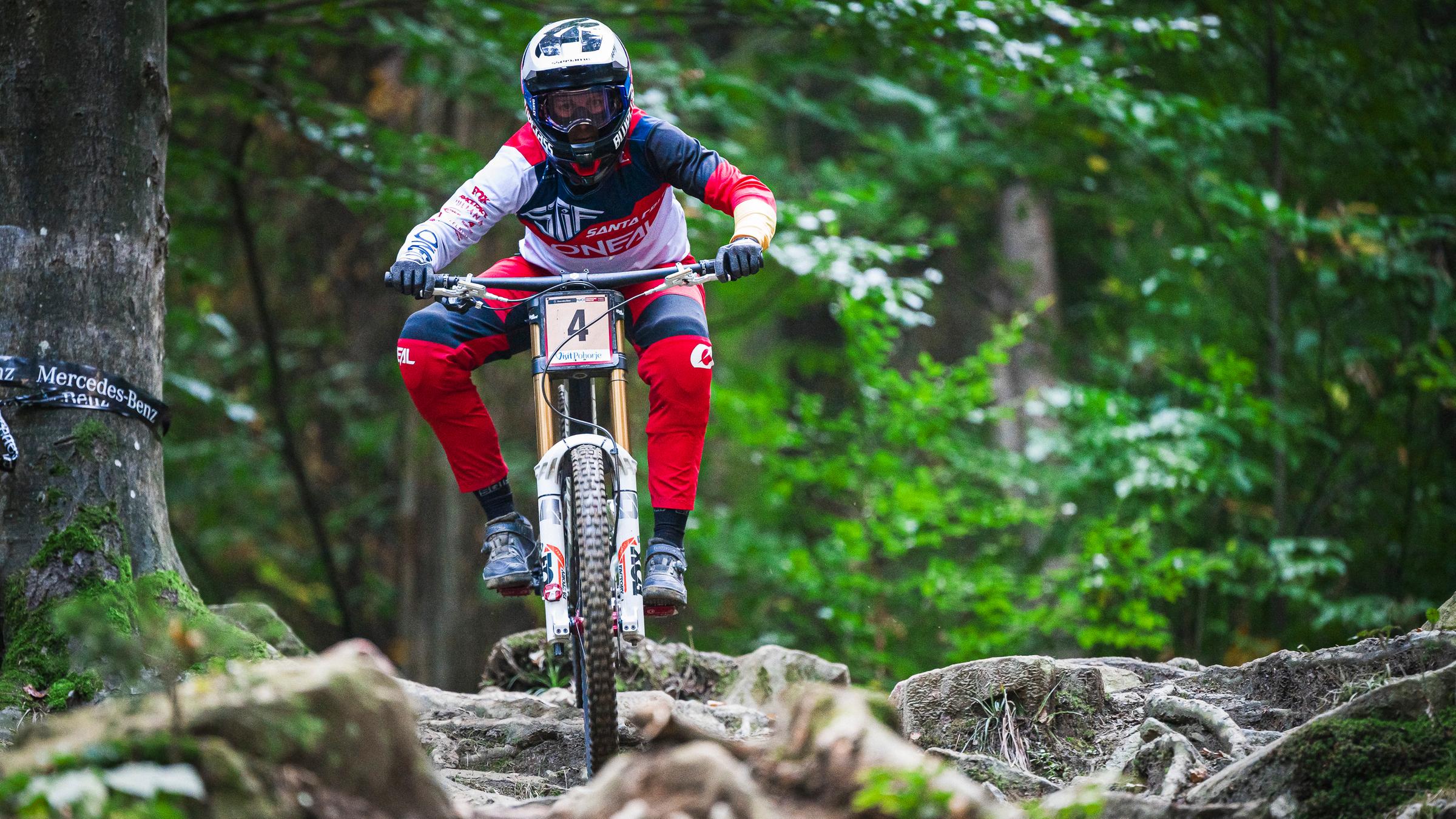 Eine Mountainbike-Fahrerin fährt über Wurzeln und Steine