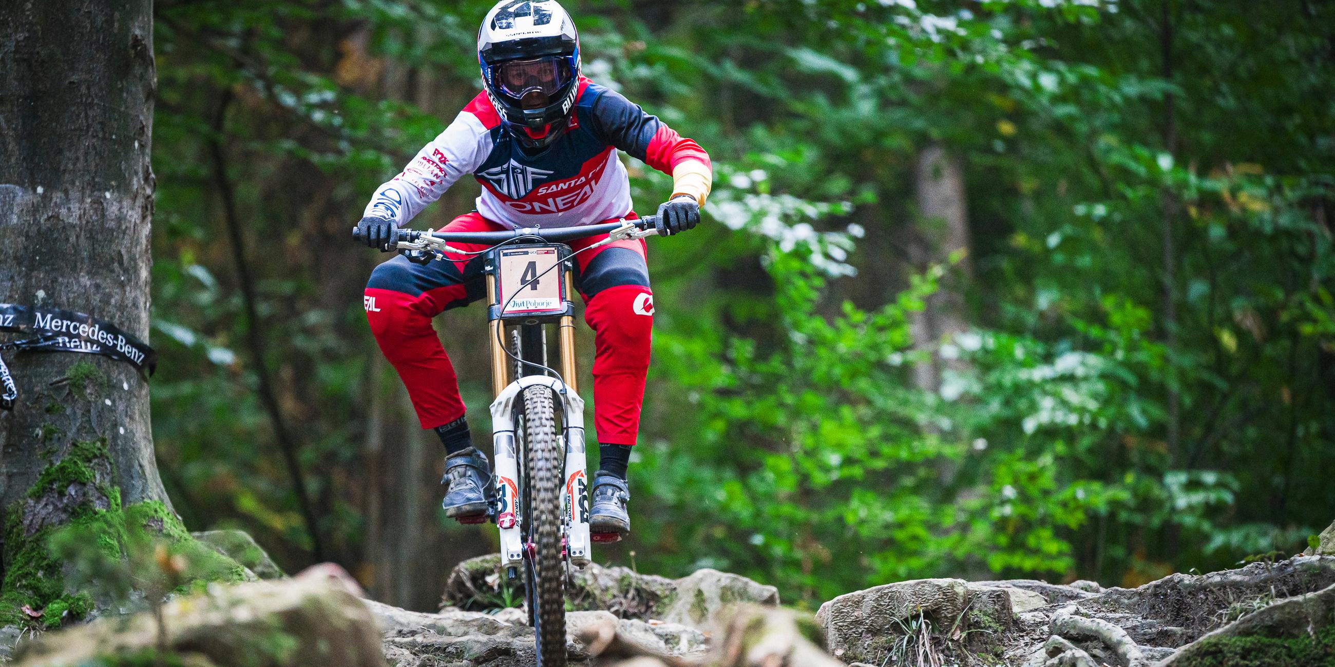 Eine Mountainbike-Fahrerin fährt über Wurzeln und Steine
