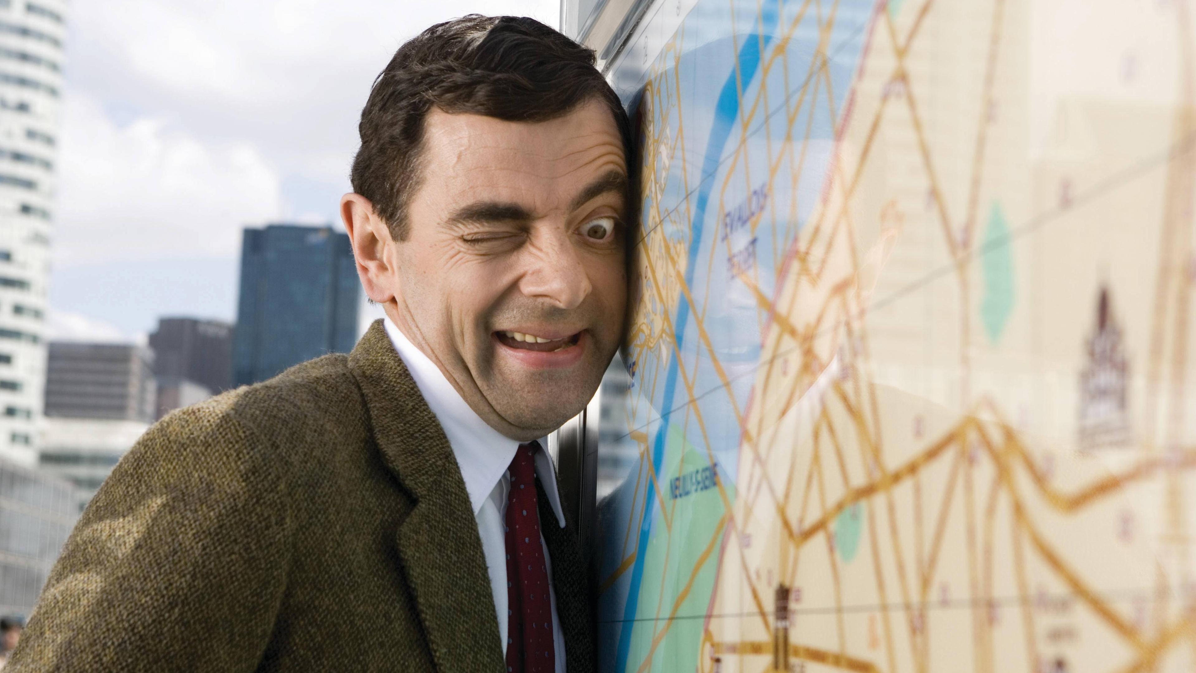 Mr. Bean lehnt an einer Weltkugel. 