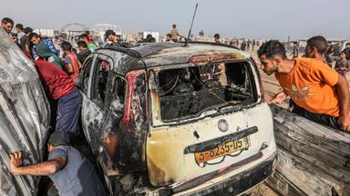 Palästinensische Gebiete, Rafah: Palästinenser inspizieren ein ausgebranntes Auto nach einem israelischen Luftangriff auf ein Flüchtlingslager.