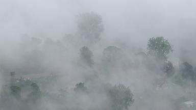 Nebel hüllt eine Ortschaft an einem Berghang in Dharamshala ein.