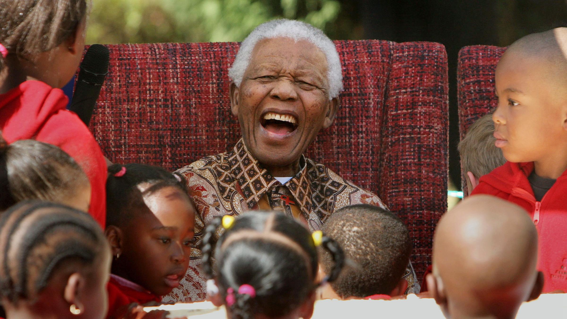 Nelson Mandela umringt von Kindern.