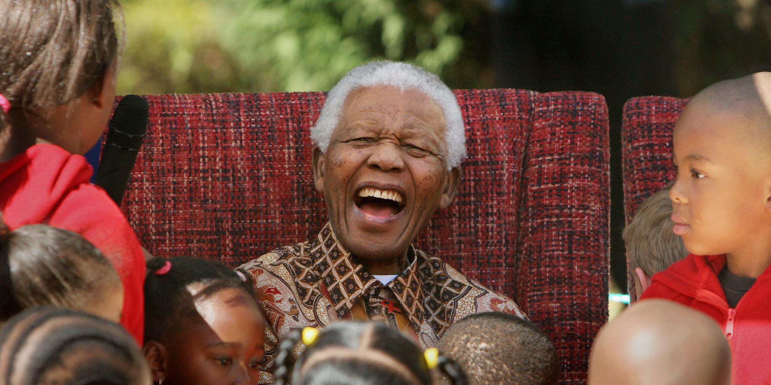 Nelson Mandela umringt von Kindern.