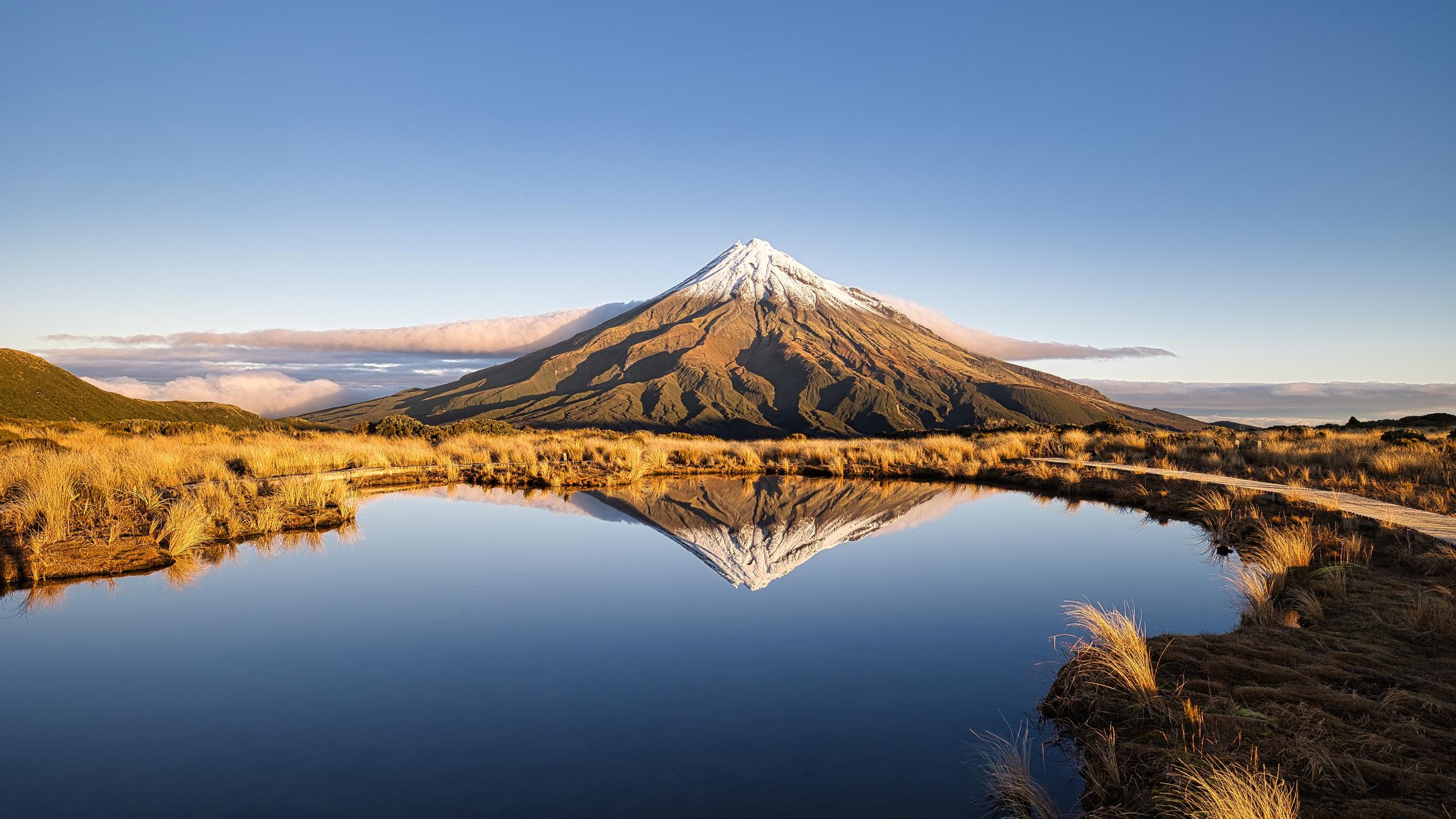 Der Vulkan Taranaki bei Wellington, Neuseeland, spiegelt sich in einem See. 