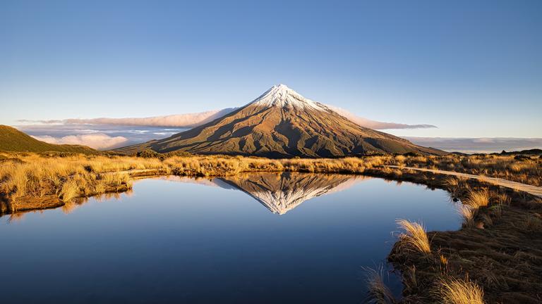 Der Vulkan Taranaki bei Wellington, Neuseeland, spiegelt sich in einem See. 