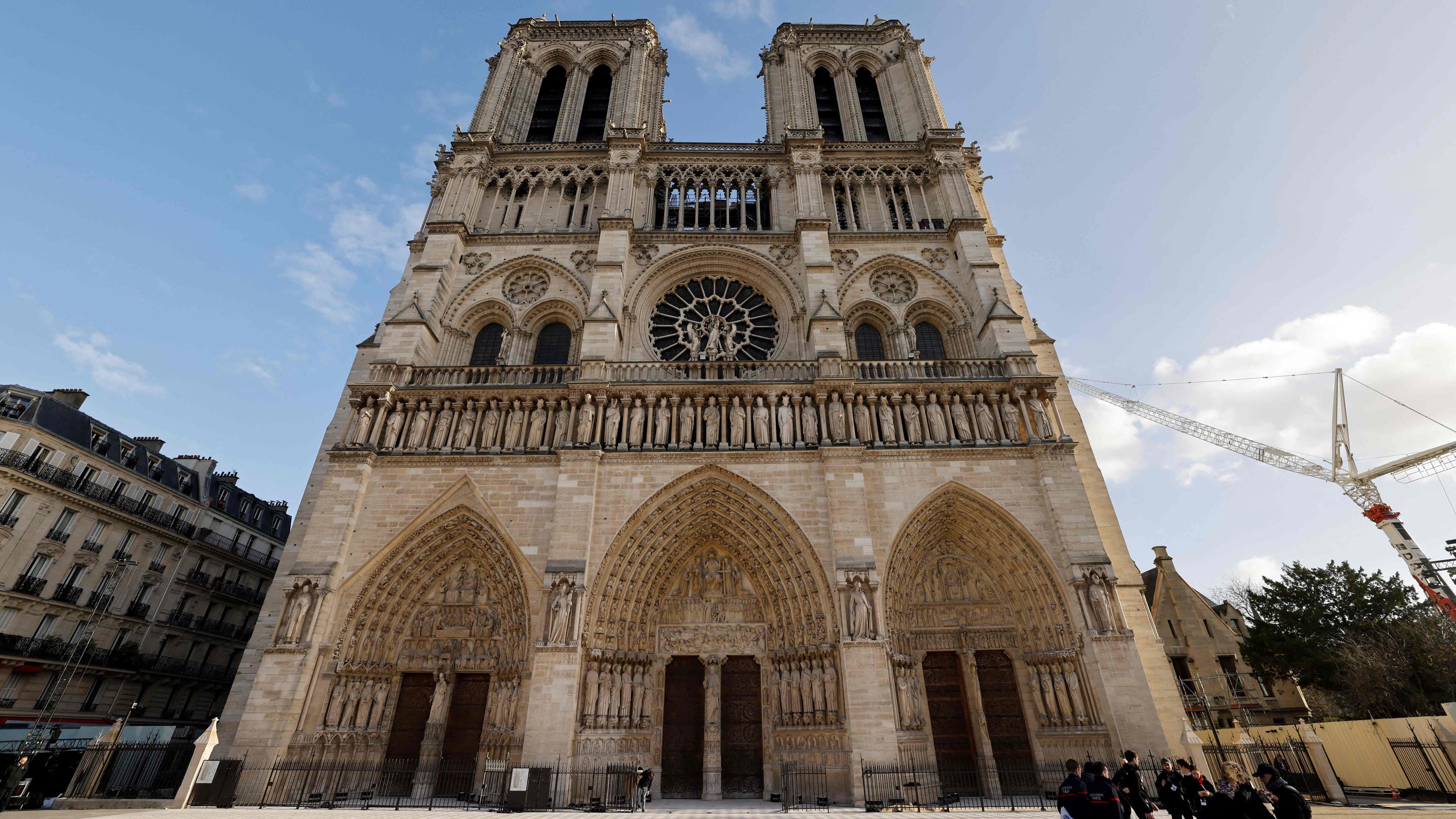Außenansicht der Notre-Dame, ein Krank steht im Hintergrund, blauer Himmel