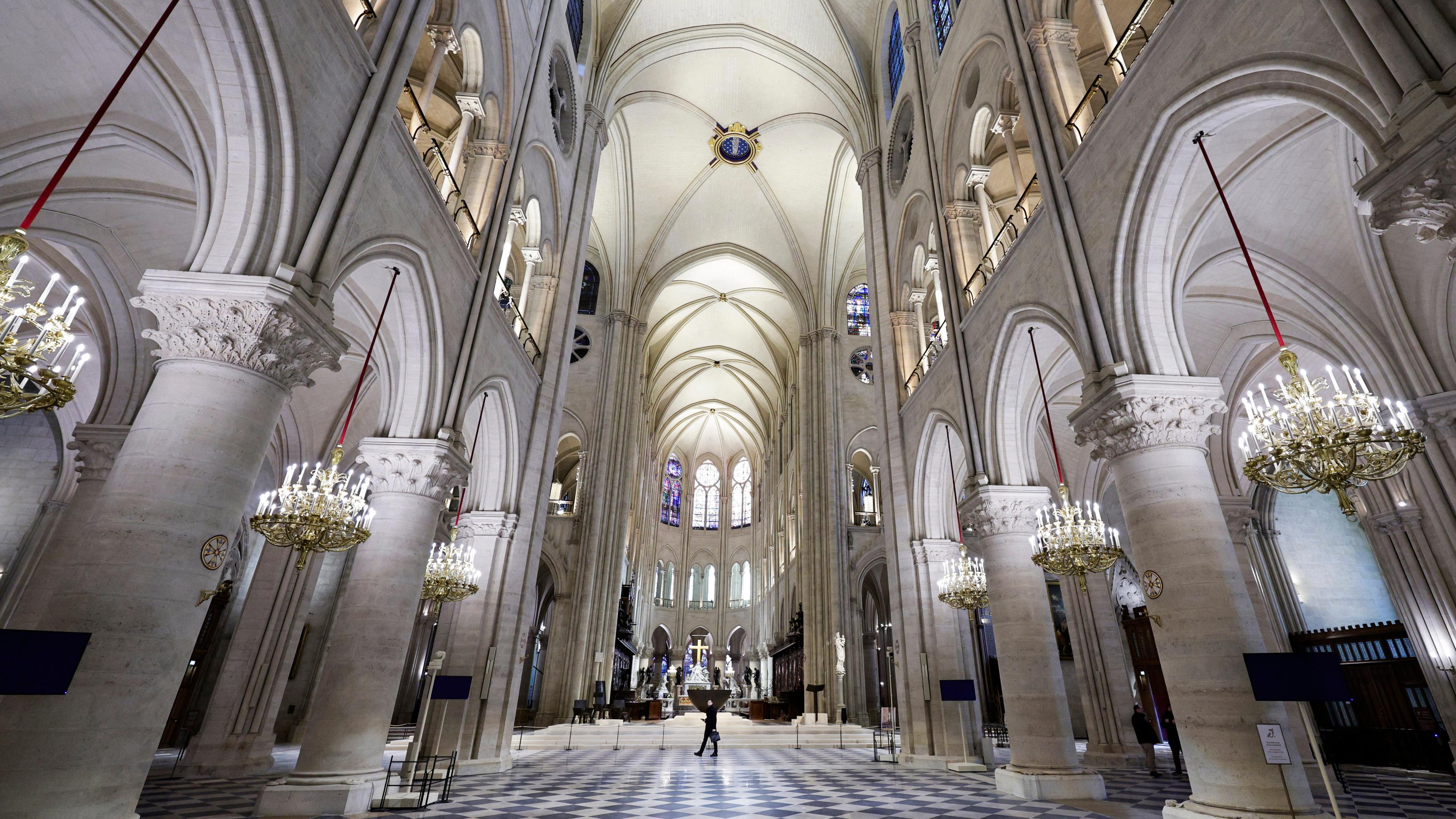 Die wieder aufgebaute Kathedrale von innenm weiße Steine, schwarz-weißer Boden, eine Person läuft in der Mitte.