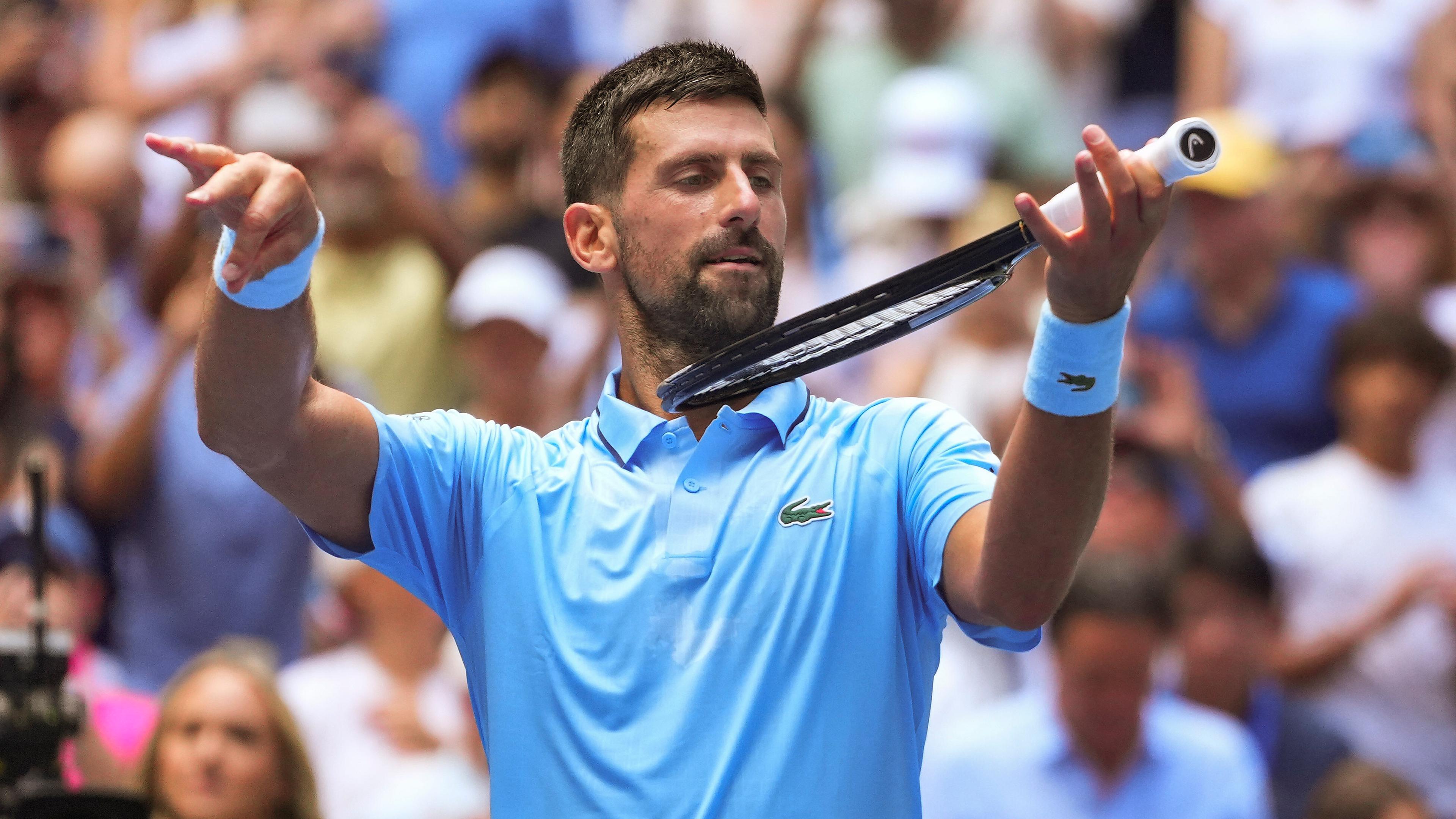 Tennisstar Novak Djokovic spielt Luftgeige auf seinem Schläger.
