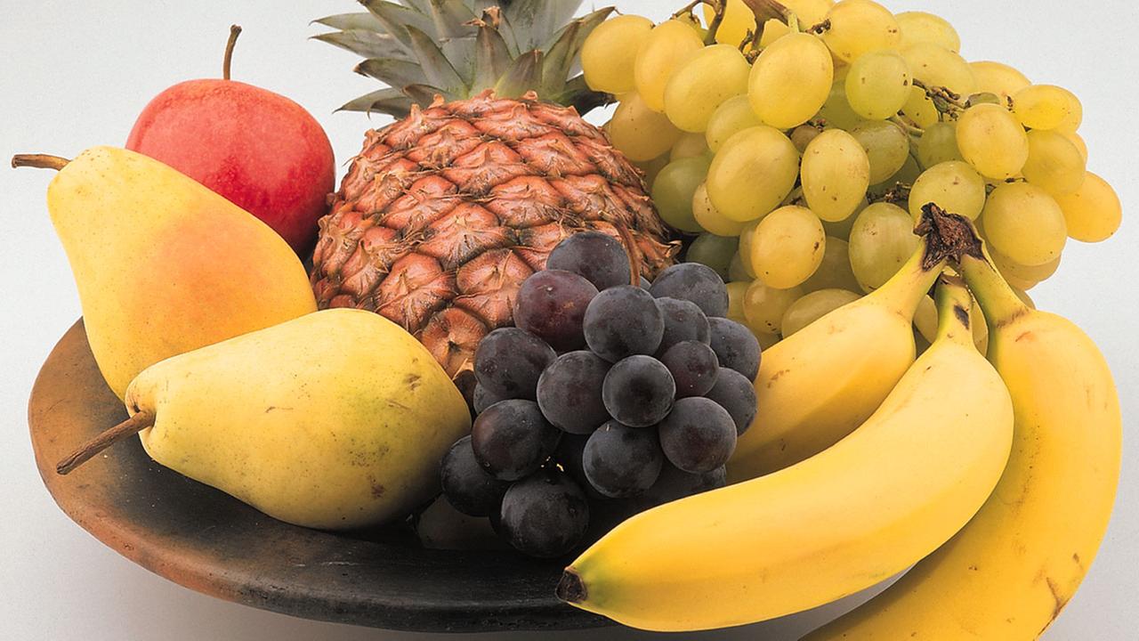 Obstschale mit Banane, Birne, Ananas und Weintrauben
