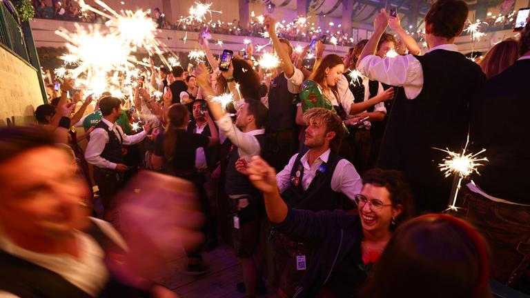 In einem Oktoberfestzelt wird mit Wunderkerzen gefeiert.