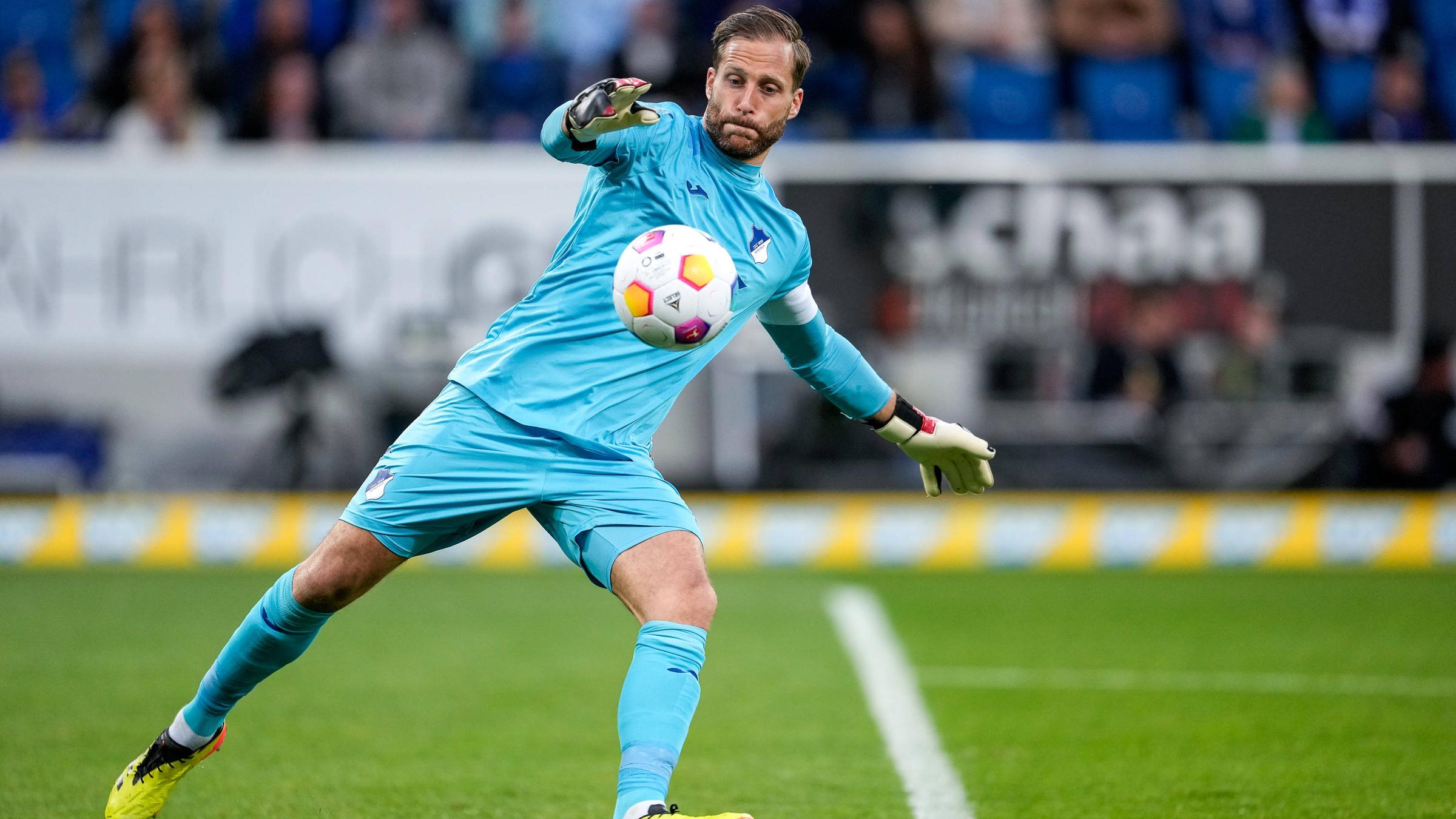 Der Fußballspieler Oliver Baumann auf dem Feld mit einem Ball.