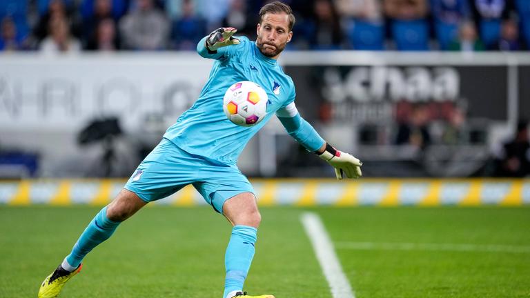 Der Fußballspieler Oliver Baumann auf dem Feld mit einem Ball.