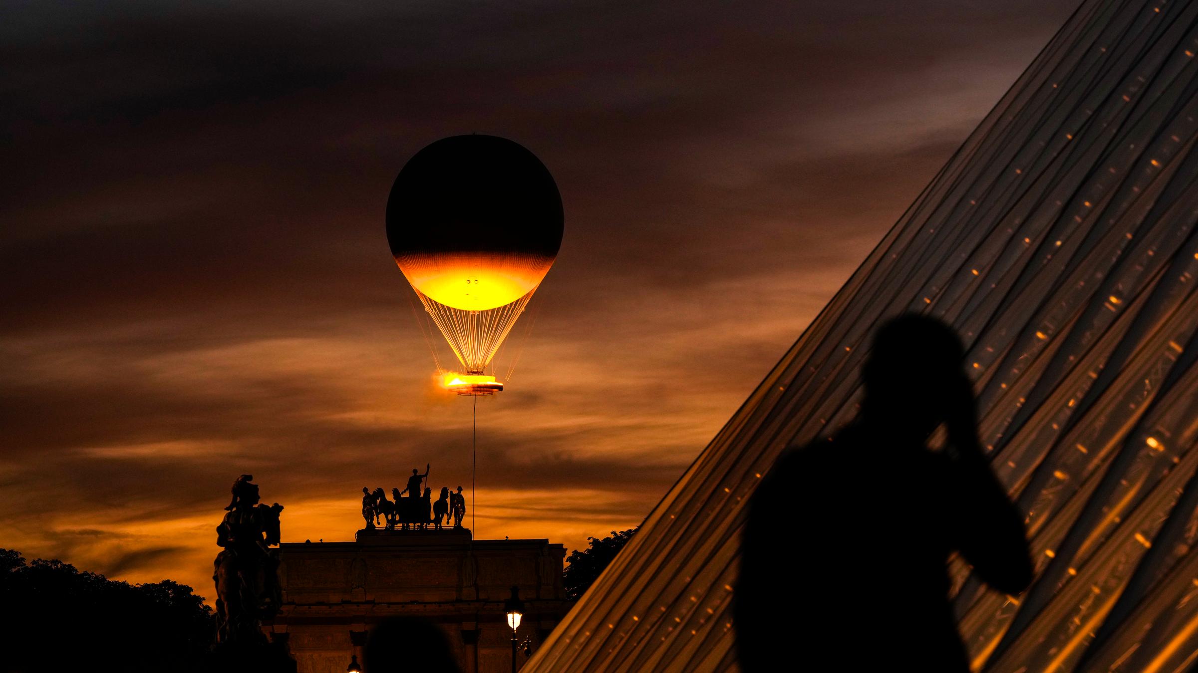Heißluftballon fliegt mit Olympischen Feuer über Paris