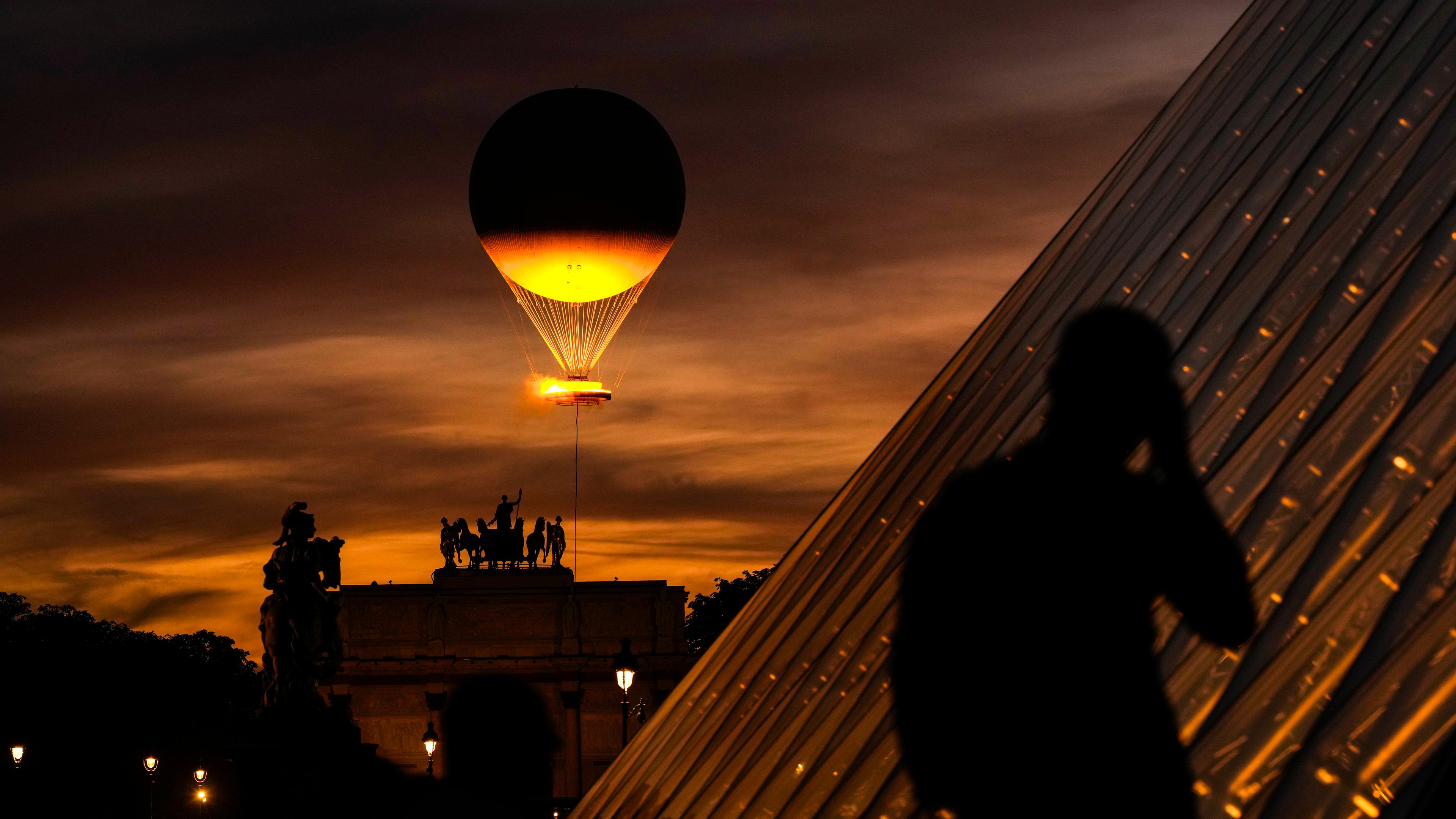 Heißluftballon fliegt mit Olympischen Feuer über Paris