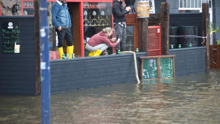 Menschen in Gummistiefeln bei Hochwasser