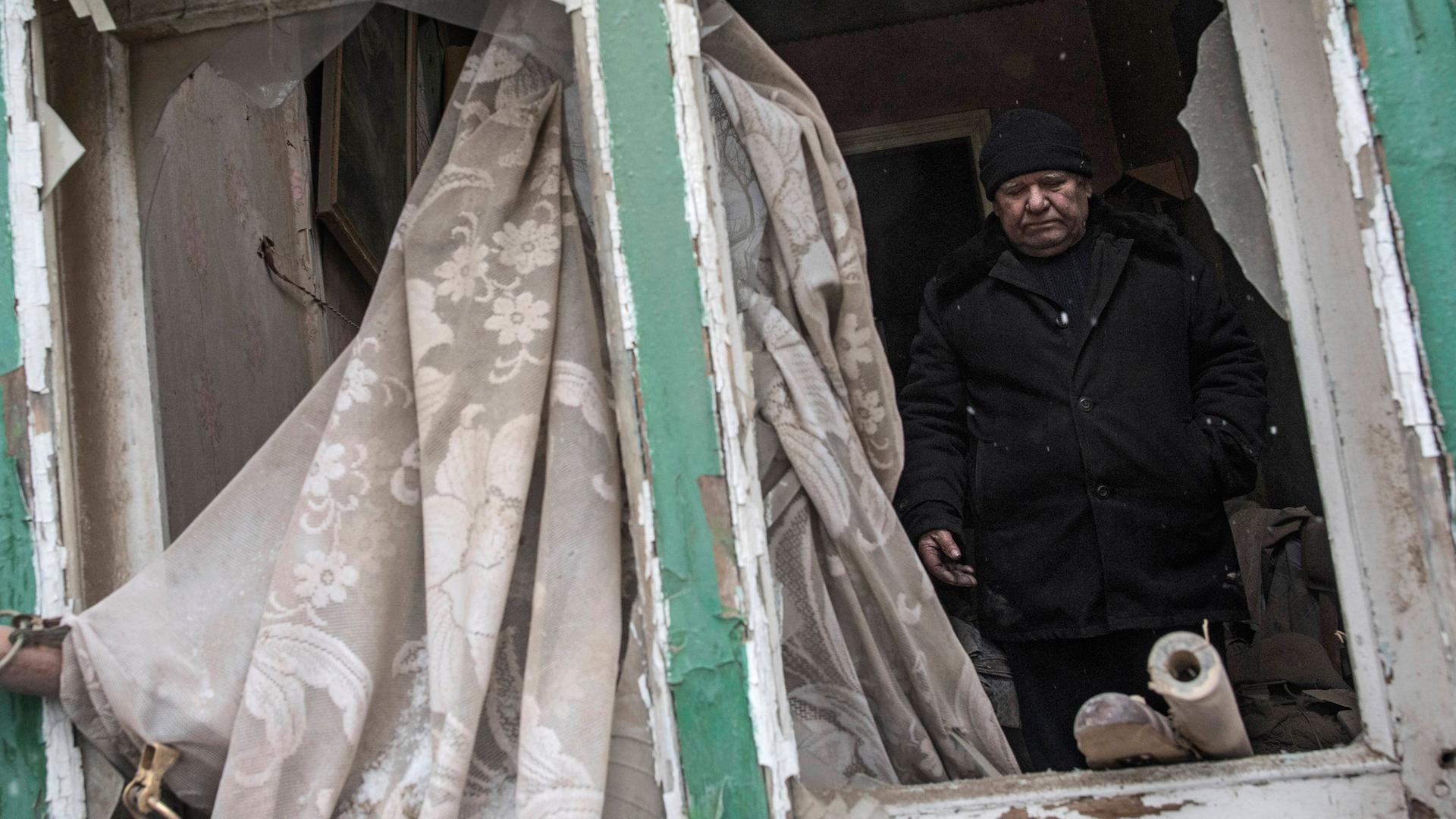 Archiv: Ein Mann steht am 02.02.2017 in seinem von Granaten zerschossenen Haus in Awdijiwka in der Ostukraine