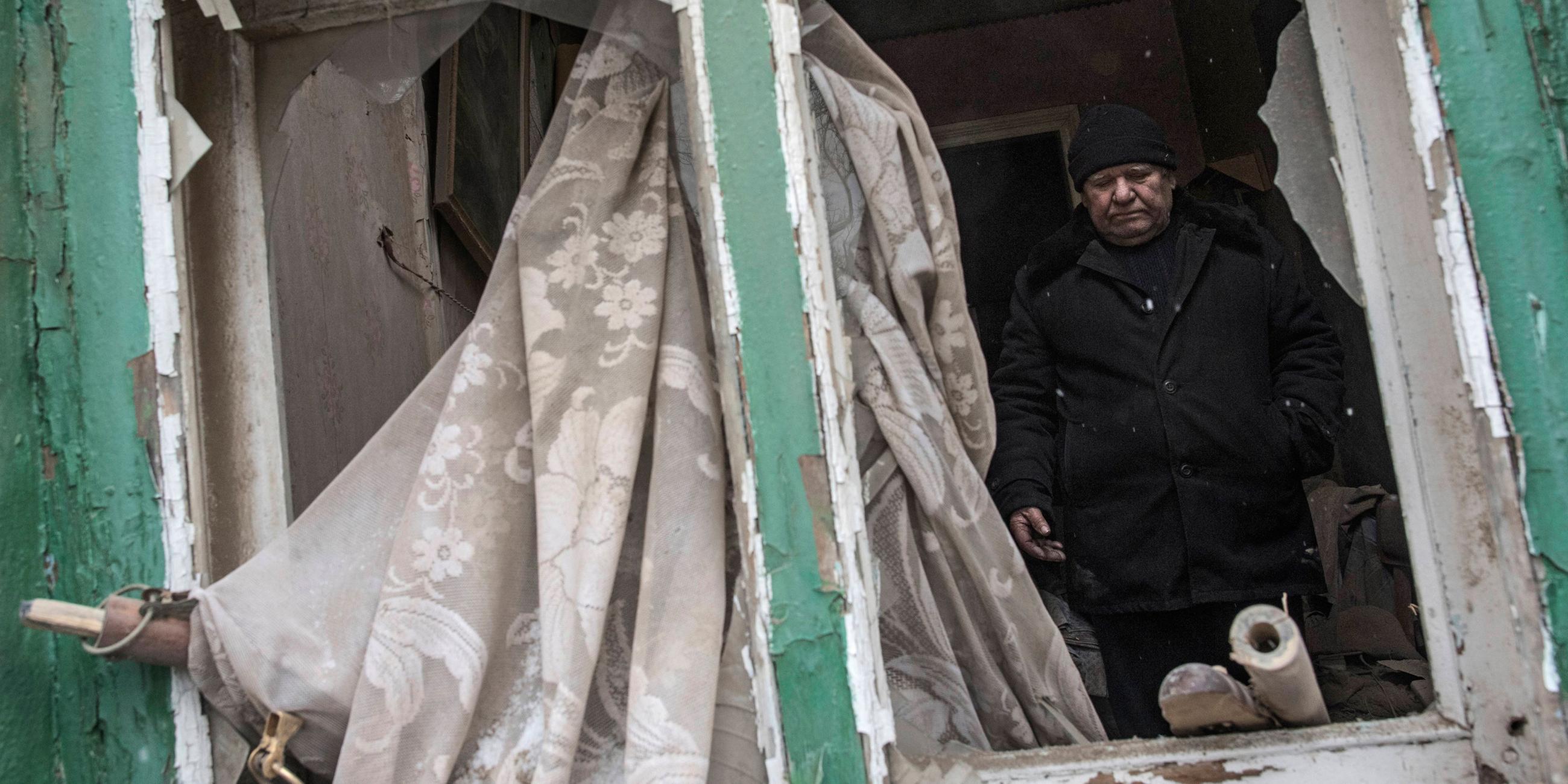 Archiv: Ein Mann steht am 02.02.2017 in seinem von Granaten zerschossenen Haus in Awdijiwka in der Ostukraine