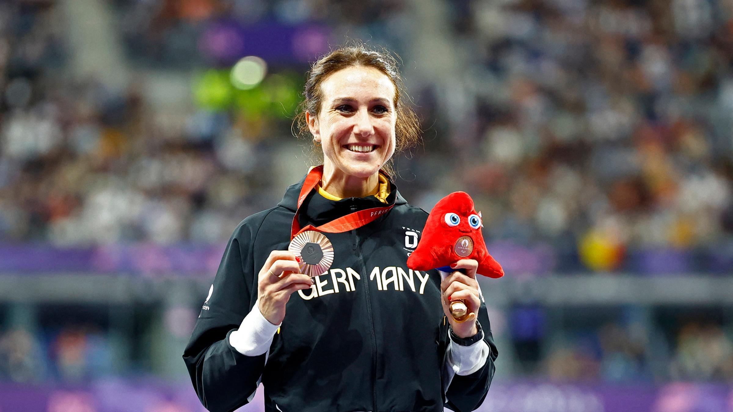 Irmgard Bensusan hält ihre Bronze Medaille in der Hand