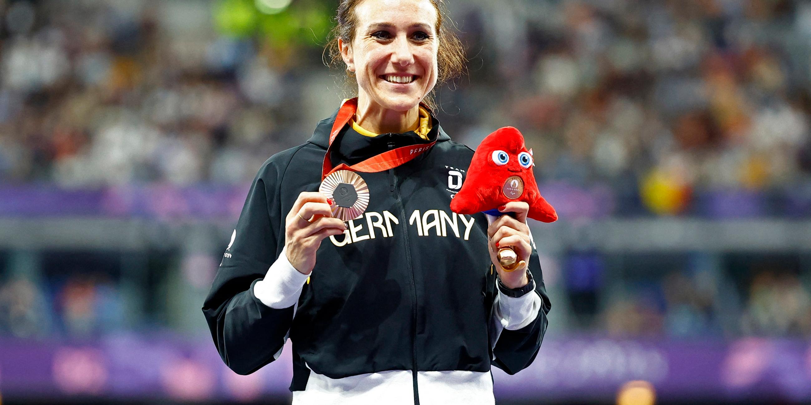 Irmgard Bensusan hält ihre Bronze Medaille in der Hand