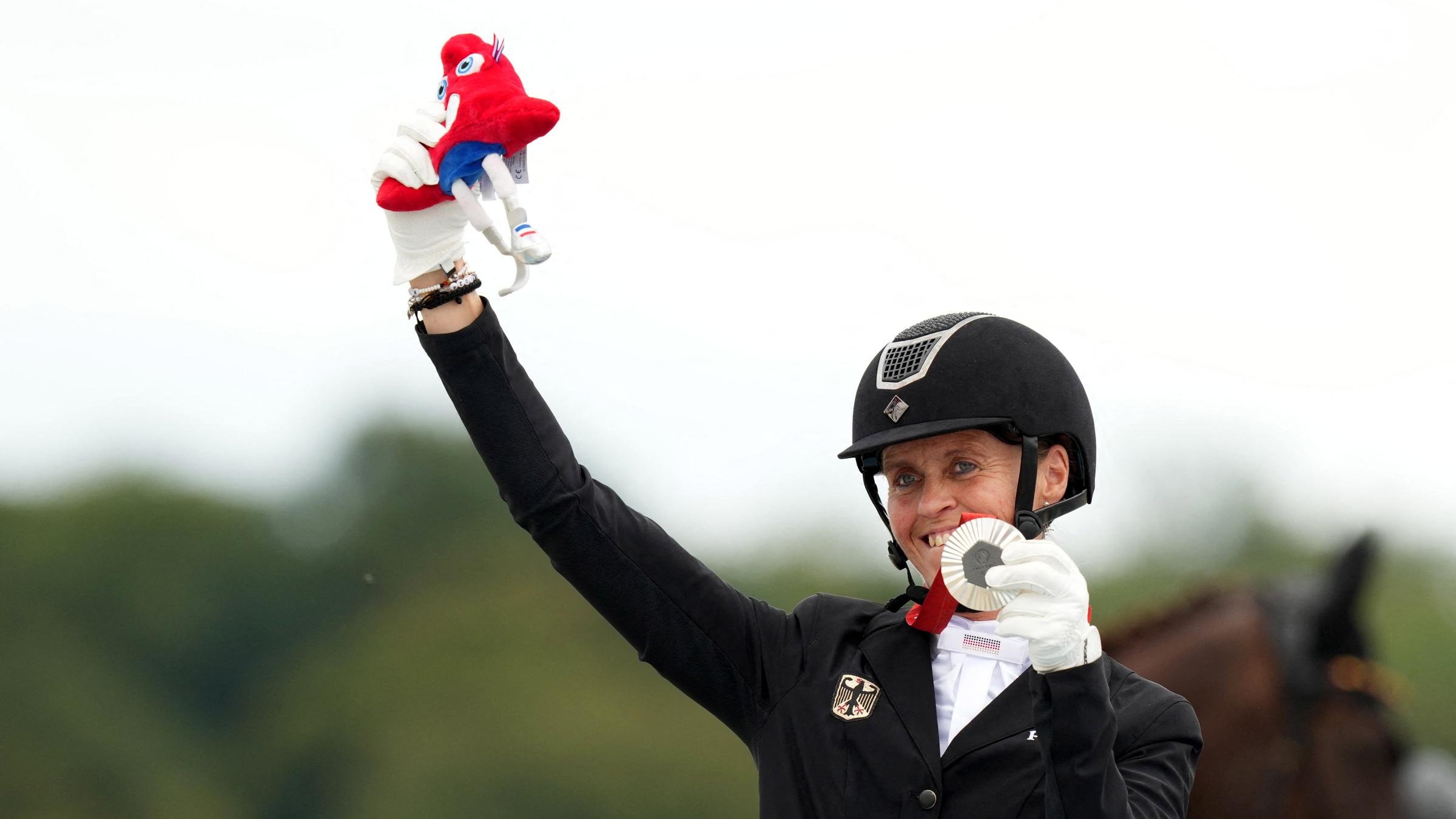 Regine Mispelkamp hält ihre Silbermedaille hoch.
