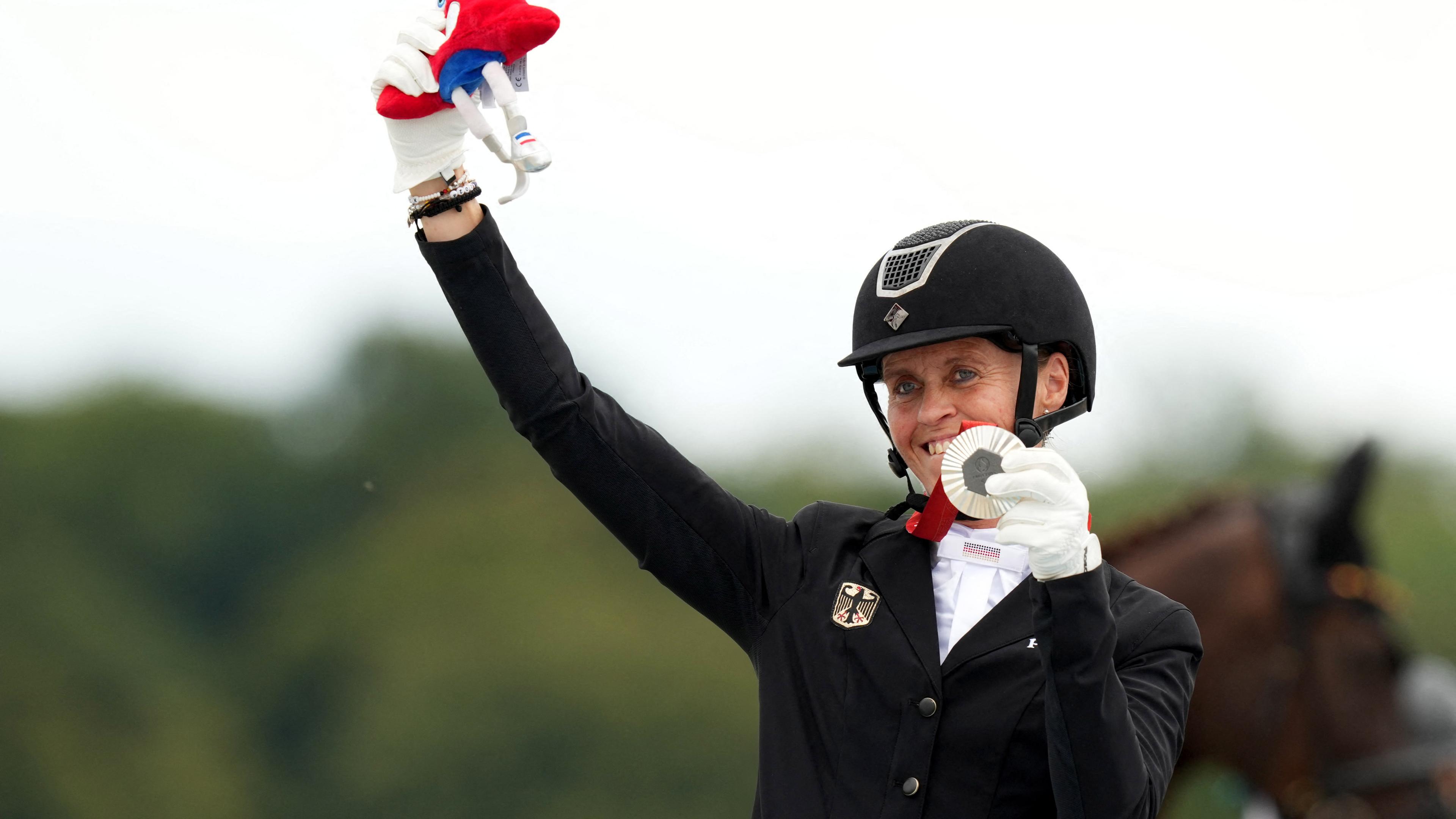 Regine Mispelkamp hält ihre Silbermedaille hoch.