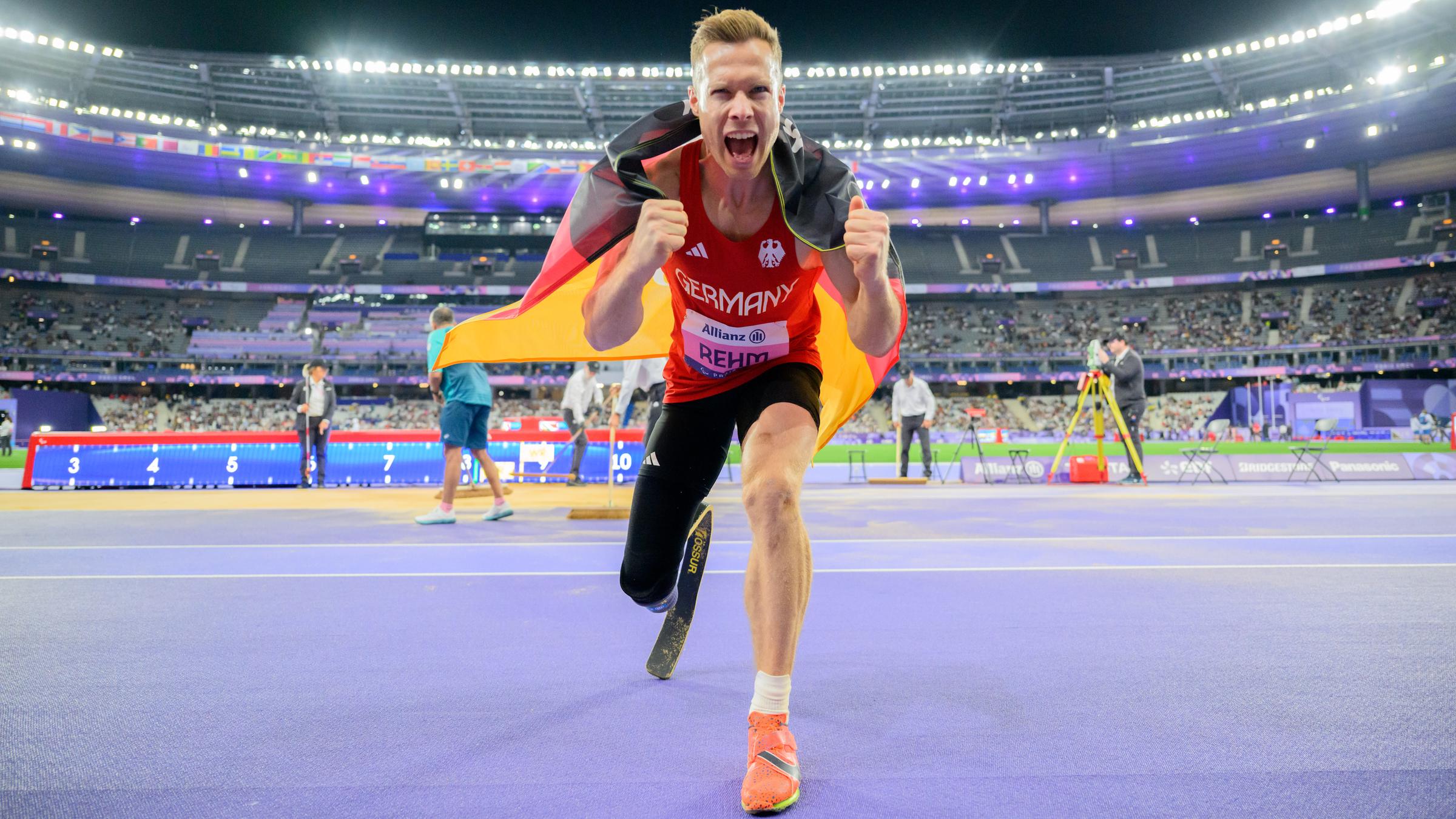 Markus Rehm jubelt mit Deutschland Flagge in der Hand.