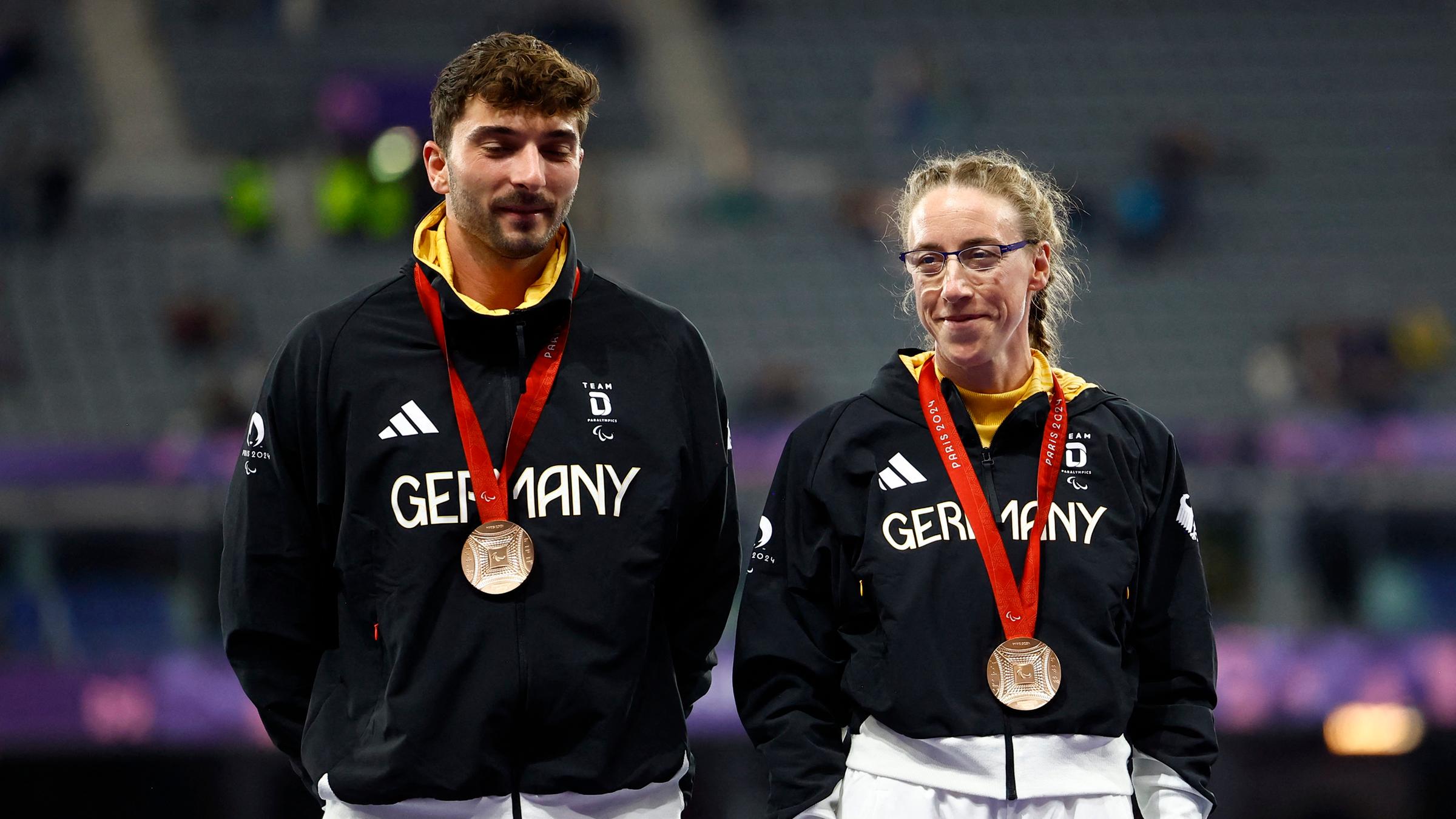 Katrin Mueller-Rottgardt und ihr Guide tragen ihre Bronze-Medaillen