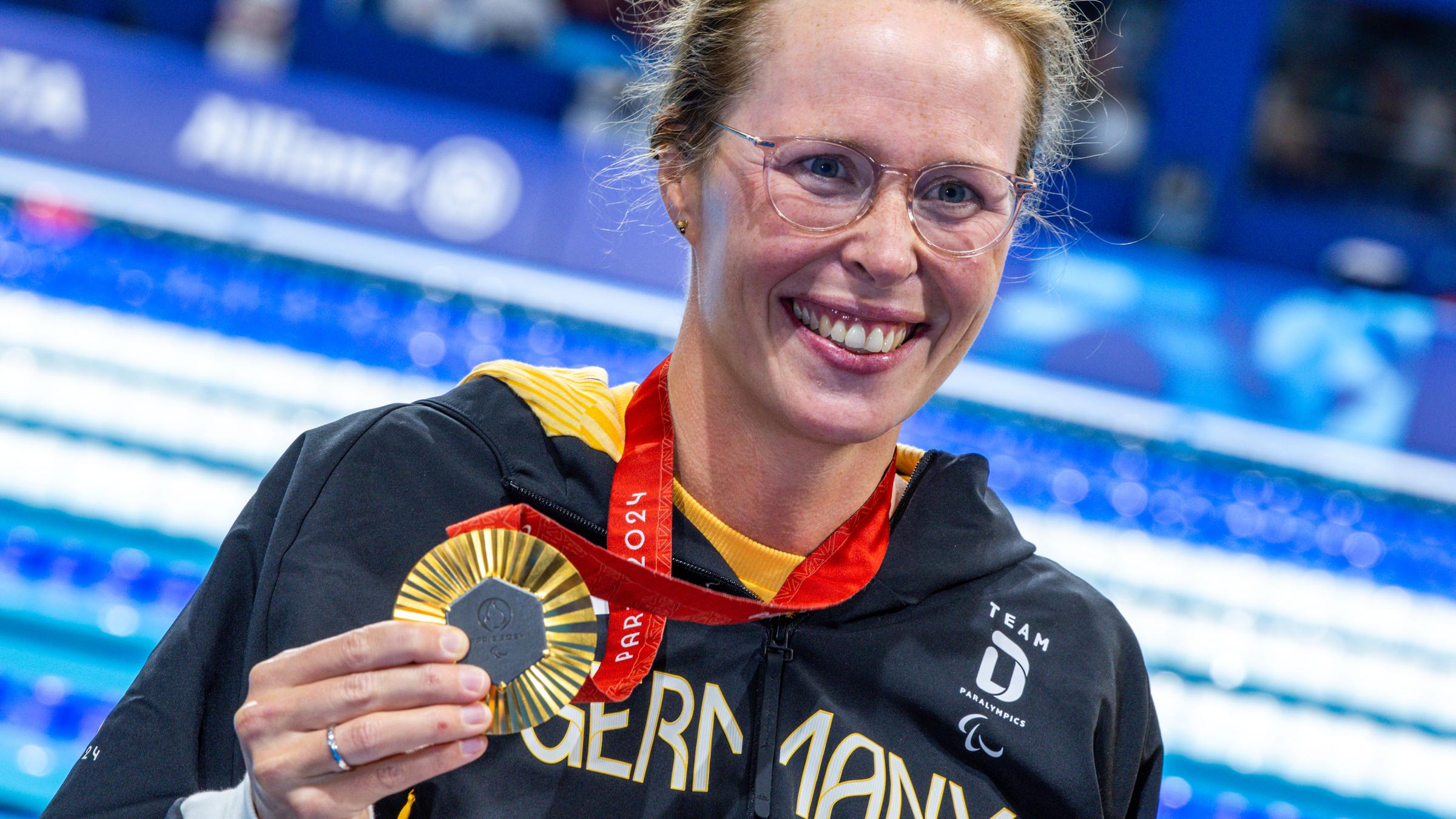 Tanja Scholz hält ihre Goldmedaille in der Hand