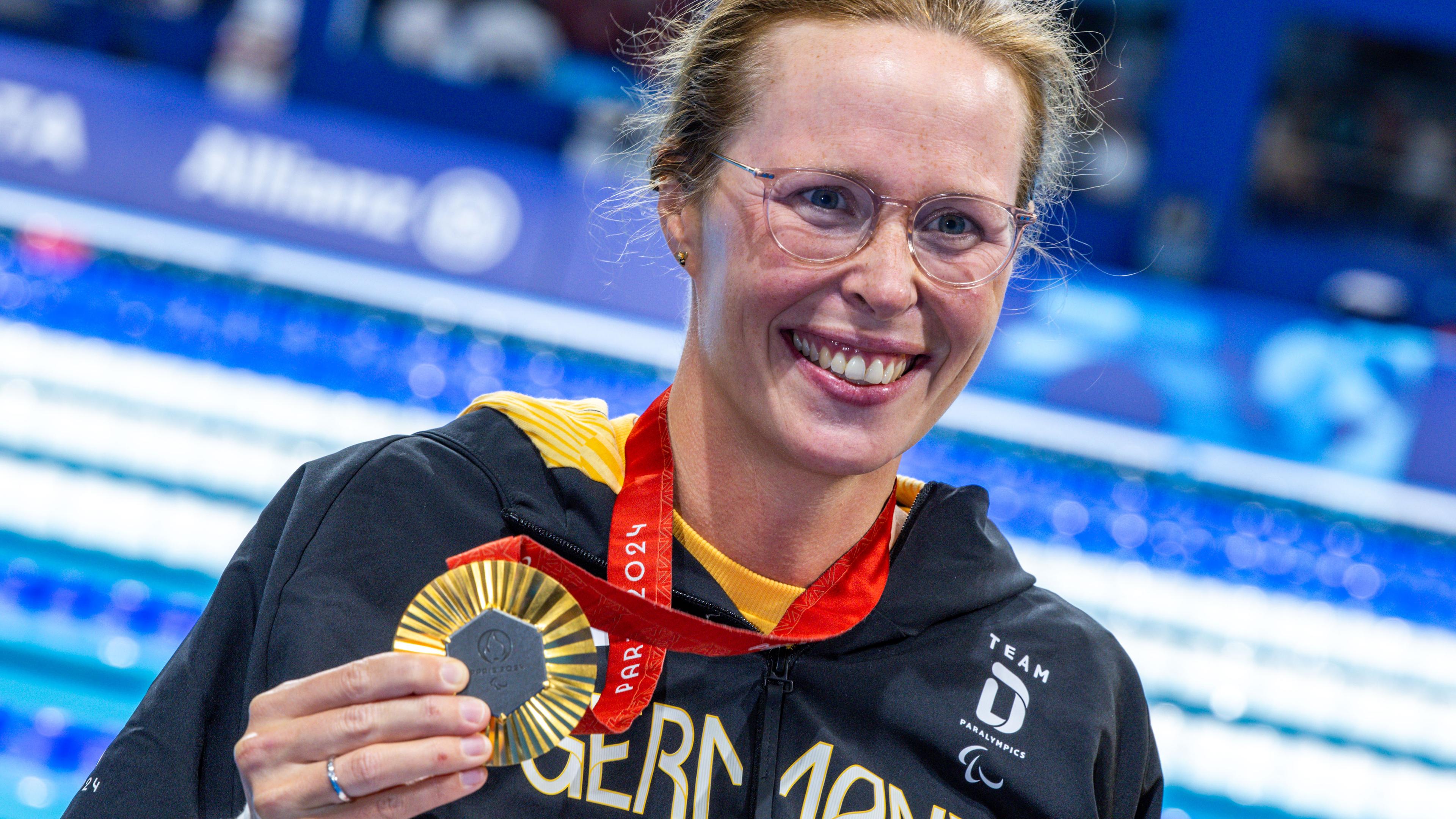 Tanja Scholz hält ihre Goldmedaille in der Hand