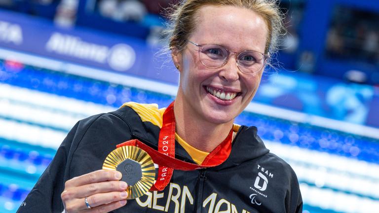 Tanja Scholz hält ihre Goldmedaille in der Hand