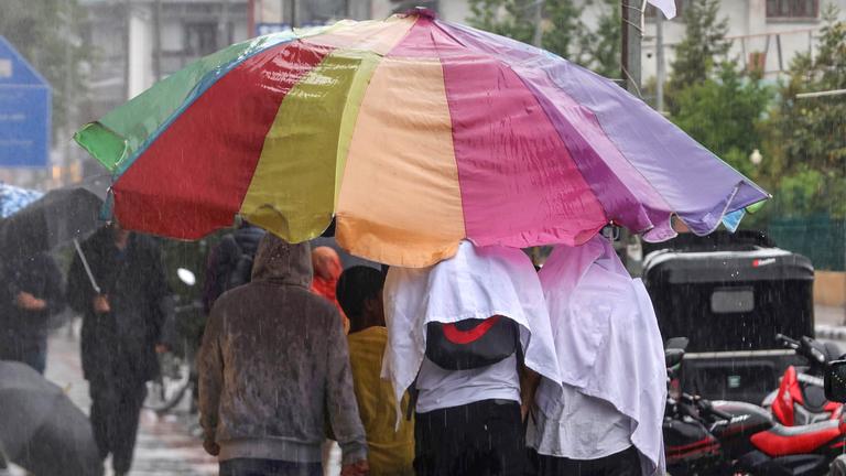 Passaten unter einem großen Regenschirm in Indien