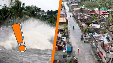 Große Wellen brechen an einer Ufermauer, davor stehen Palmen und Menschen mit Regenschirmen